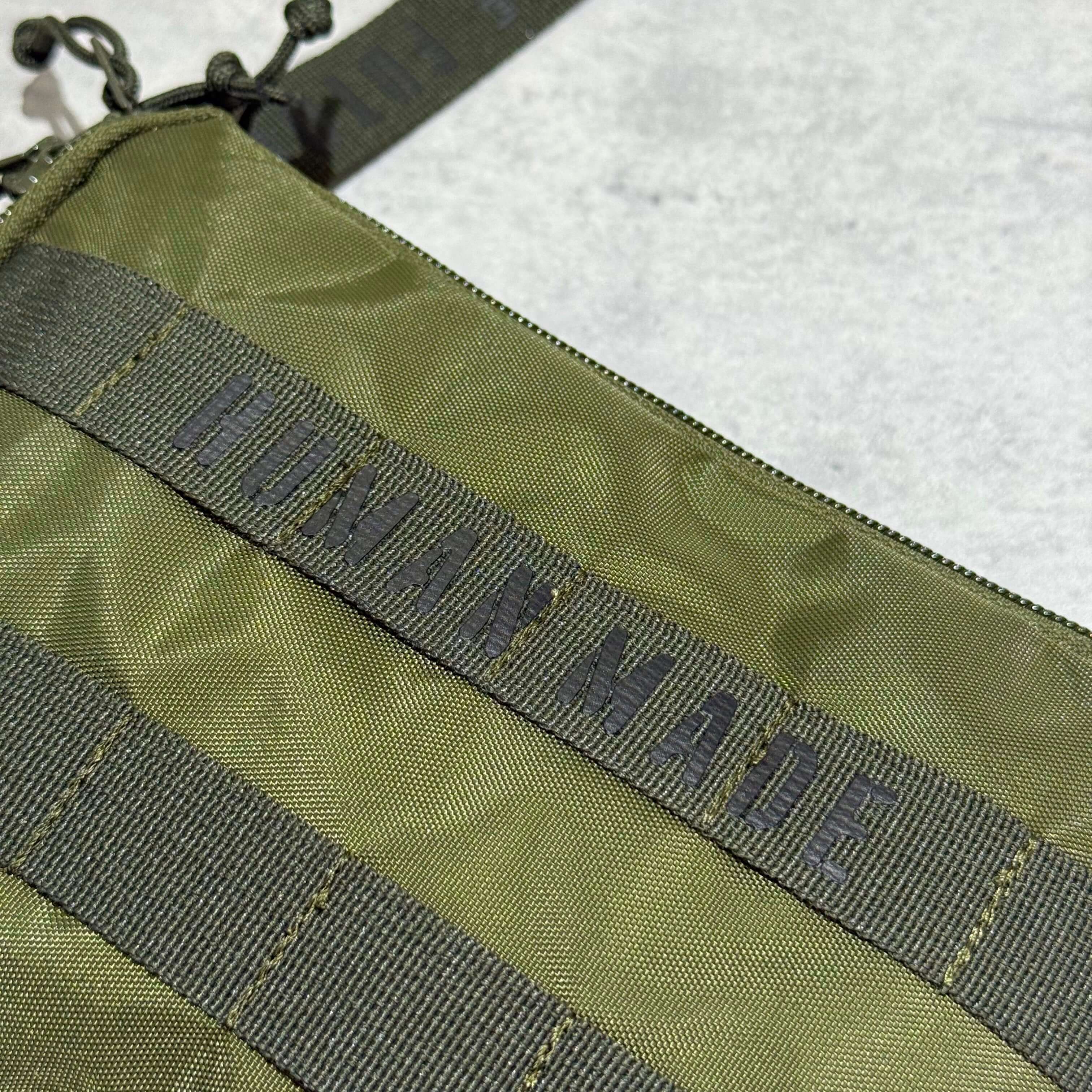 Human Made Military Pouch close-up showing green fabric and logo detail.