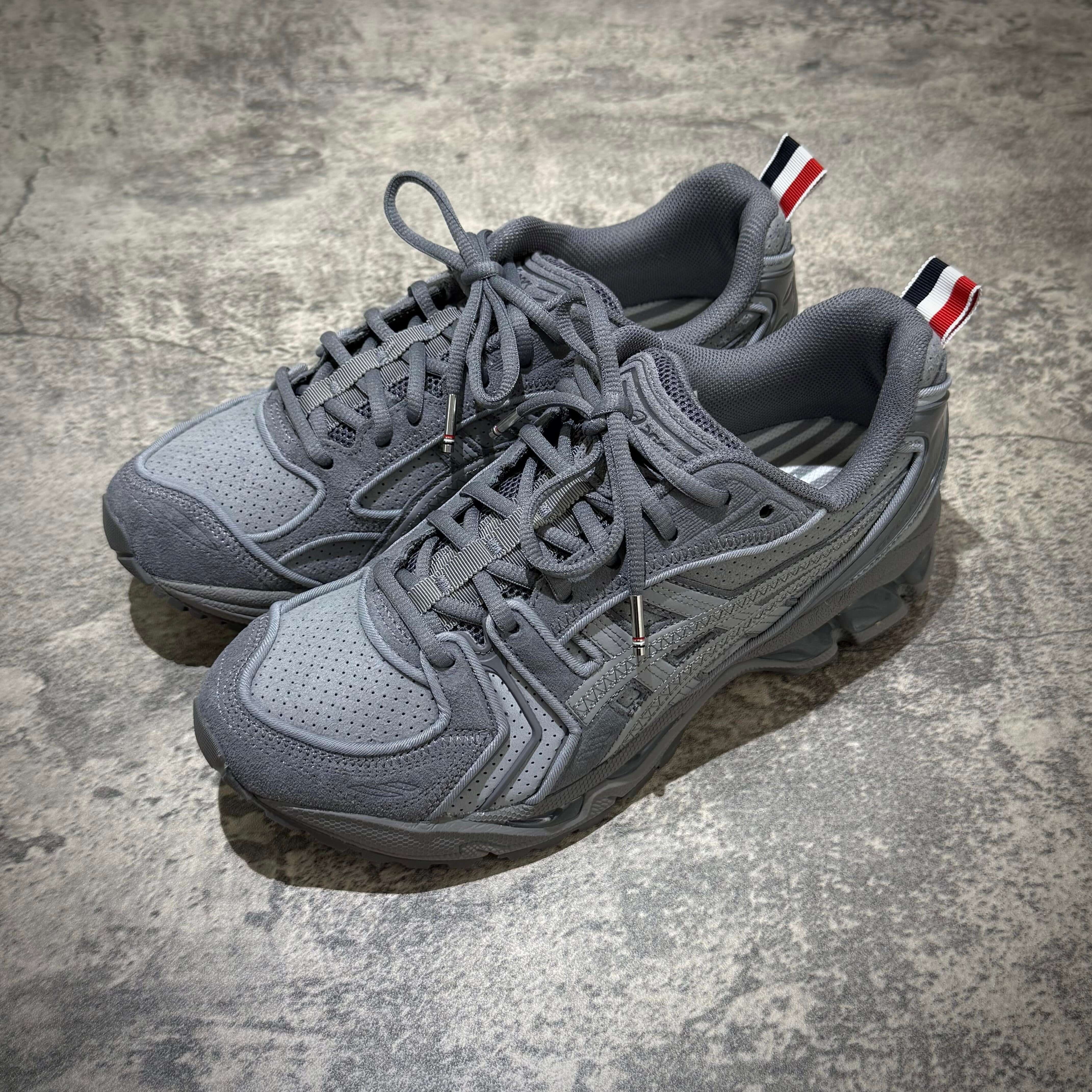 Thom Browne x Asics Gel-Kayano 14 in grey showcasing a sleek design and premium materials, perfect for any sneaker enthusiast.