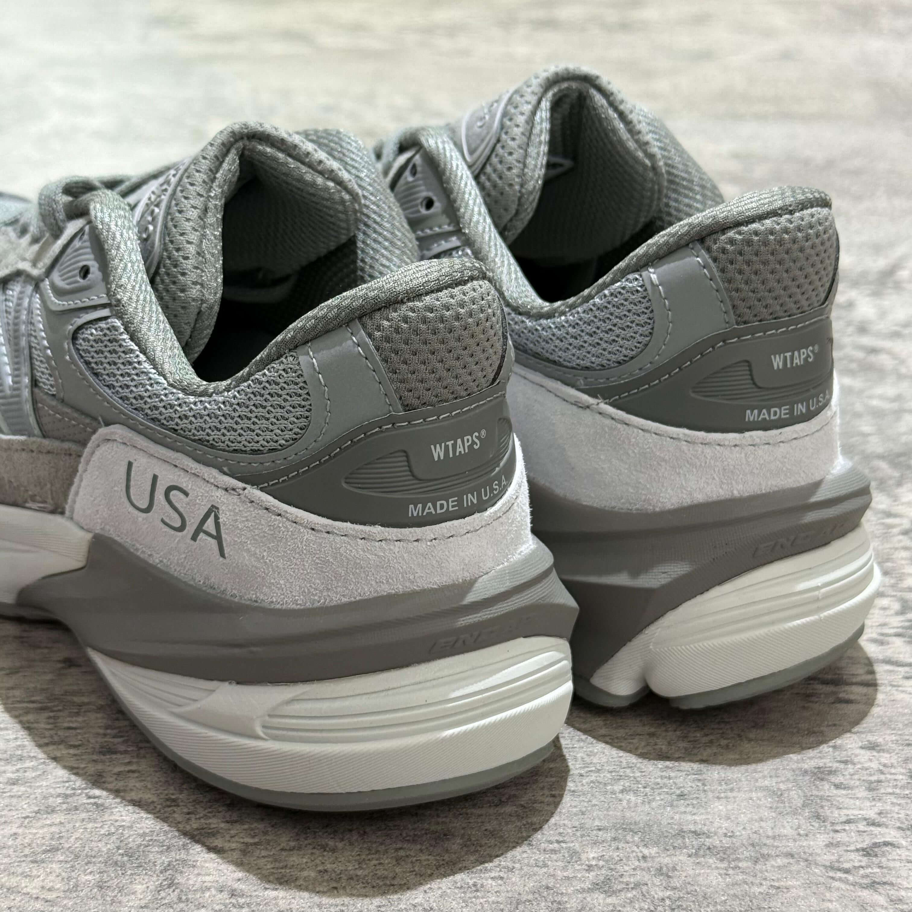 New Balance x Wtaps 990v6 sneakers showcasing the rear view with USA and Wtaps branding.