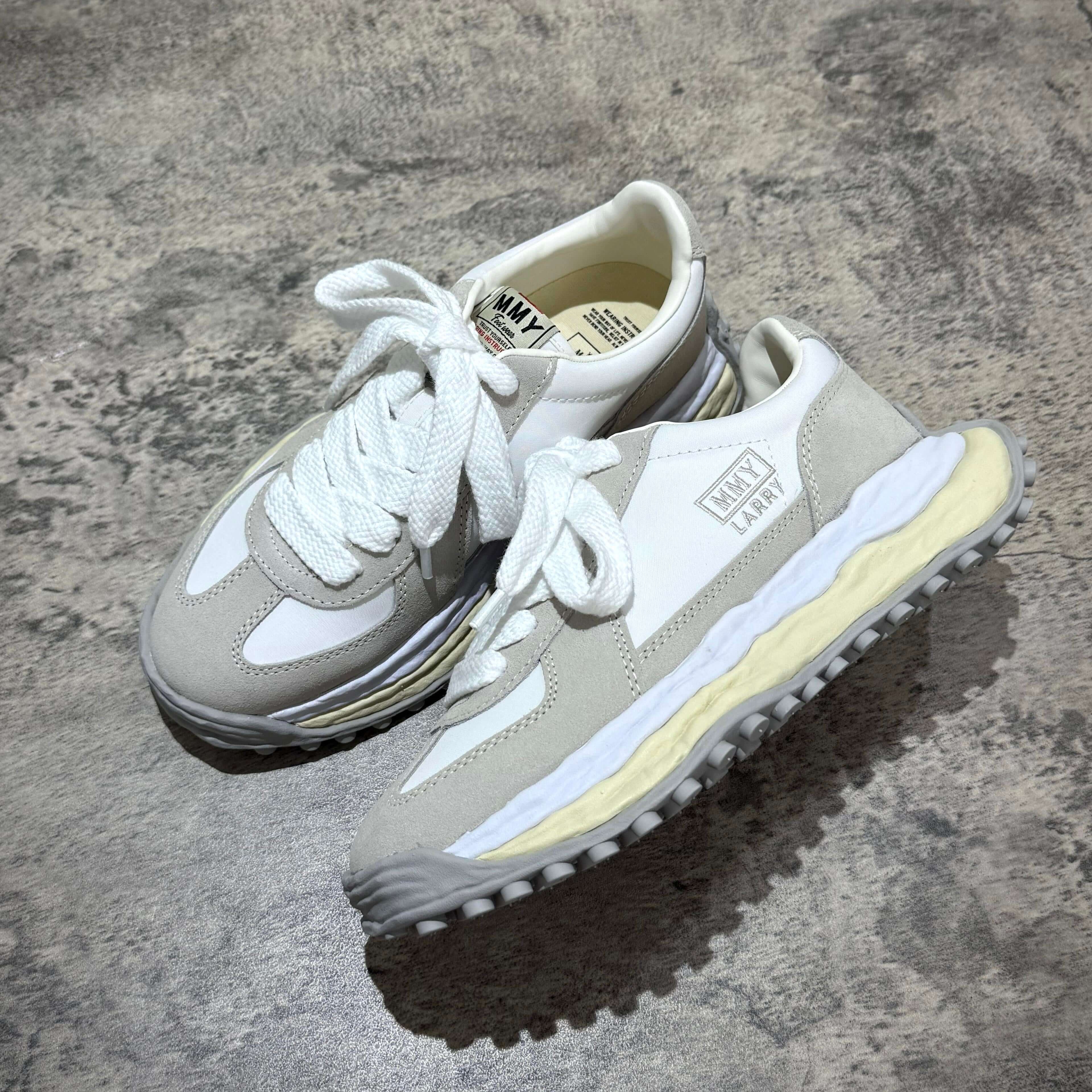 MMY Larry Leather Low - White sneakers with oversized design on a textured surface.