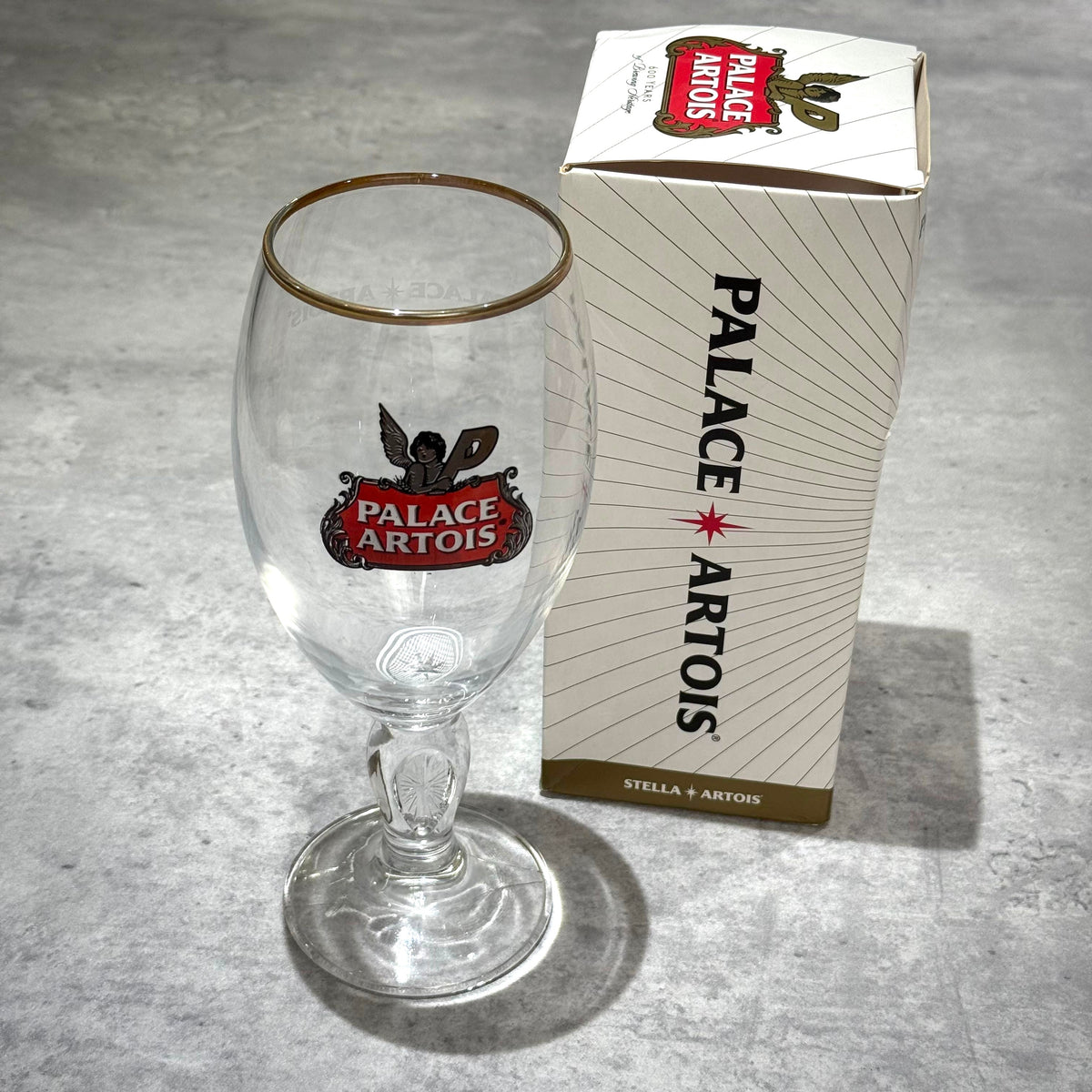 Palace x Stella Artois 500ML Pint Chalice - Clear with box on a grey surface.