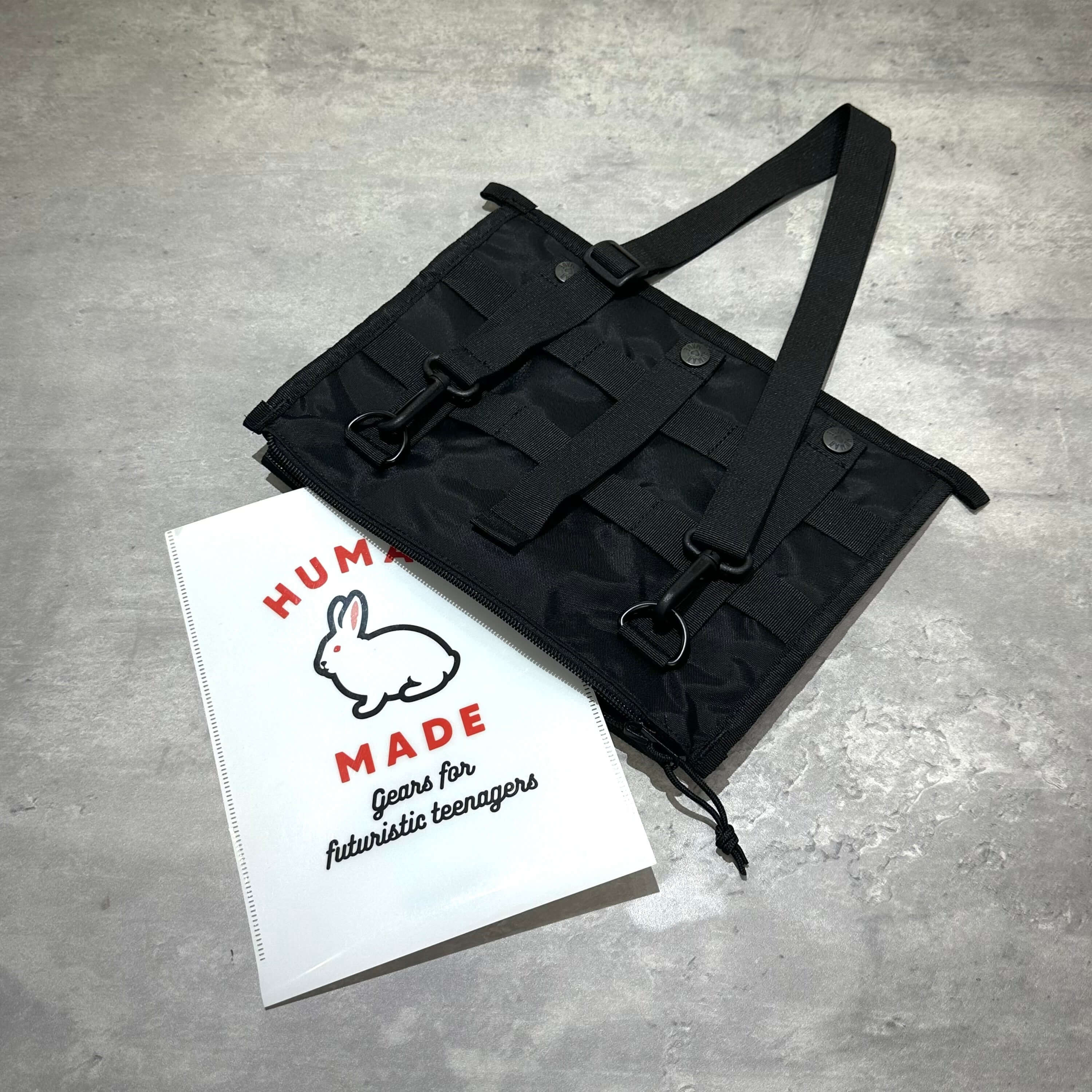 Human Made Military Shoulder Bag HM32GD011 與 Human Made 品牌手冊,從上方角度拍攝的黑色包包