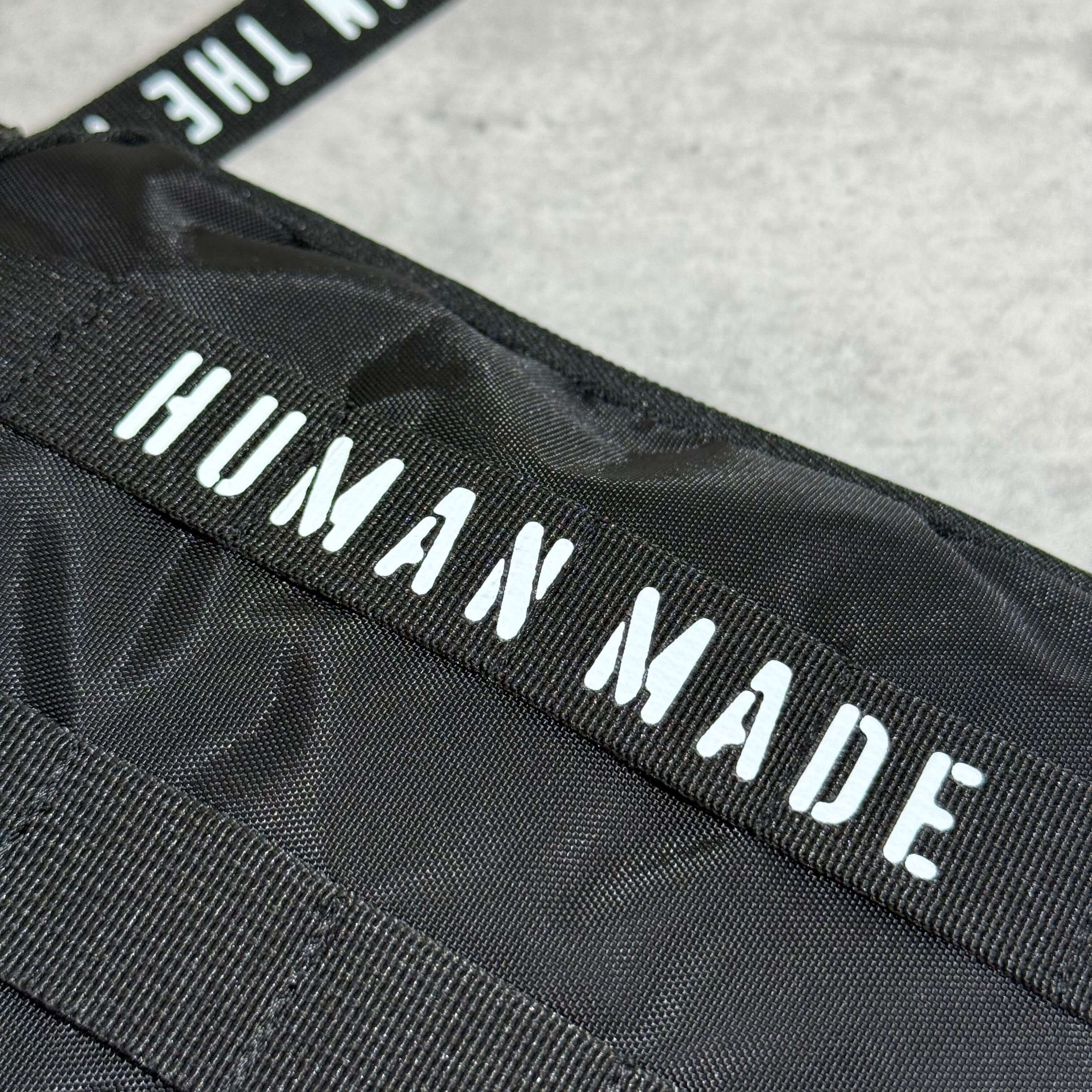 Close-up of the Human Made Military Pouch showcasing the brand label on durable fabric.