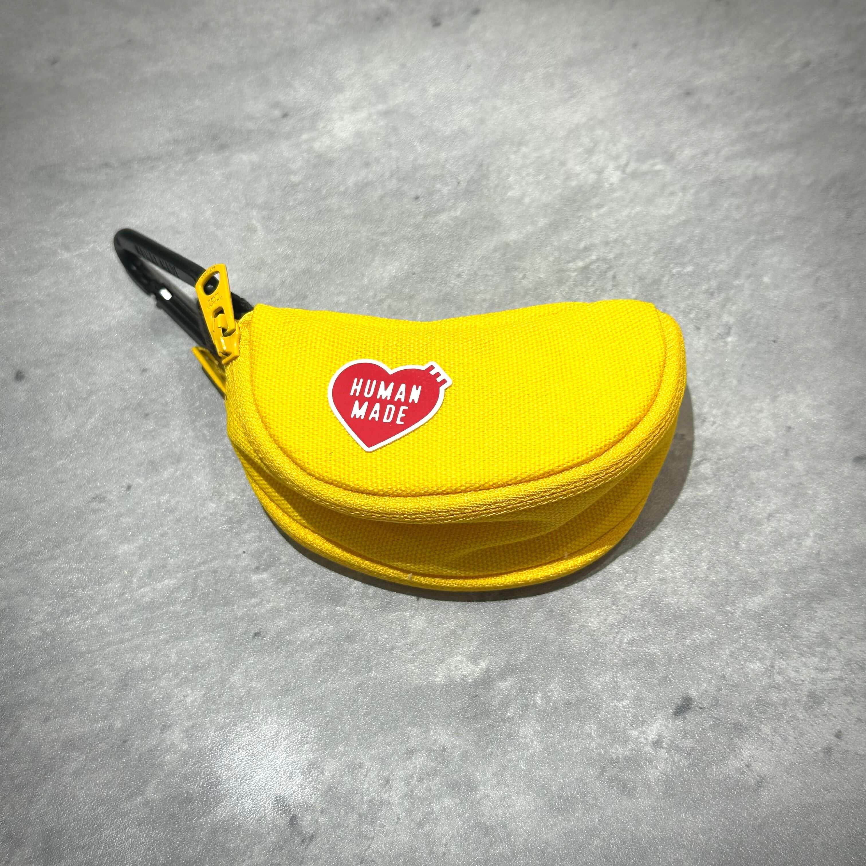 Human Made Banana Pouch in bright yellow color with logo, featuring zipper and clip.