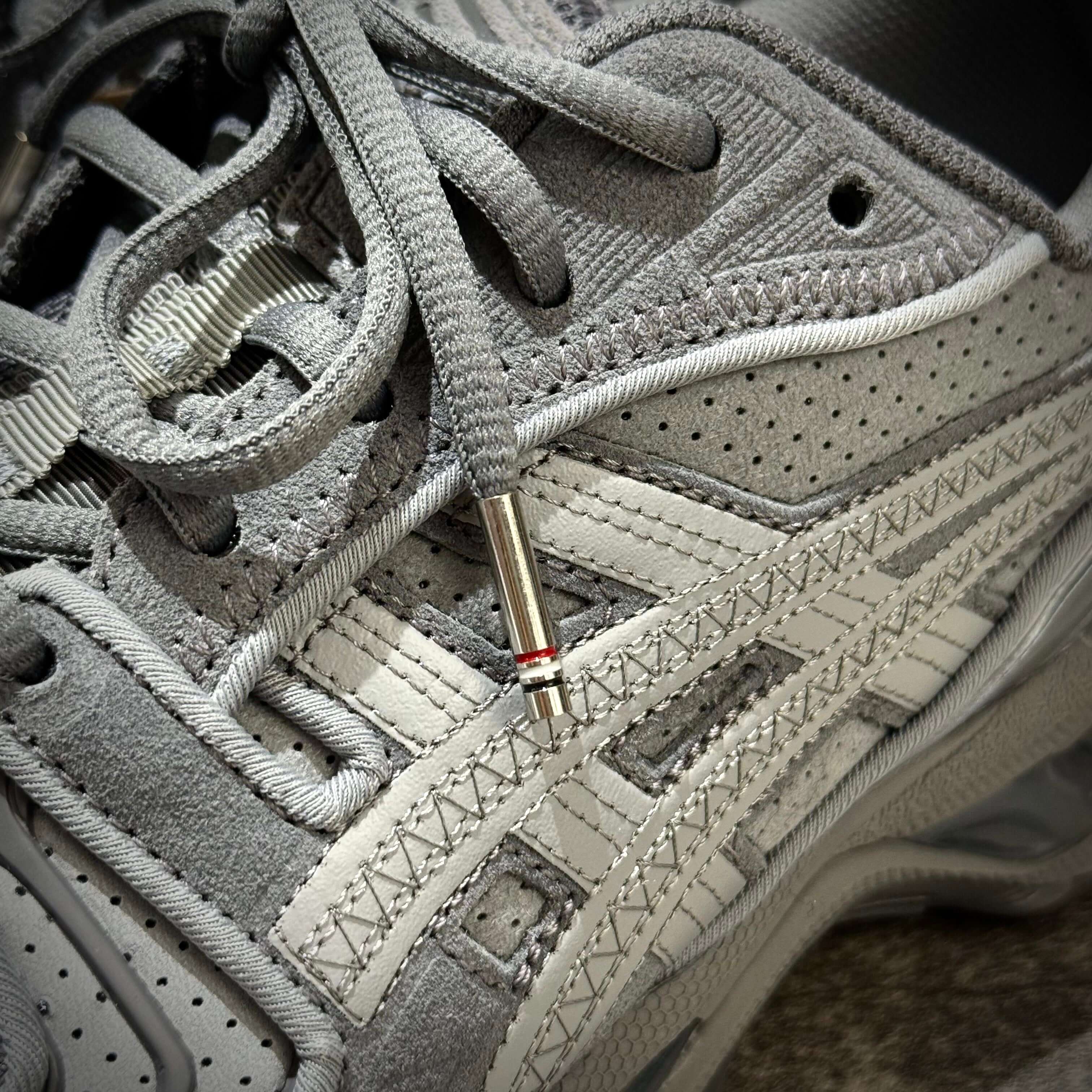 Close-up of Thom Browne x Asics Gel-Kayano 14 in grey showcasing details of the shoe design and laces.
