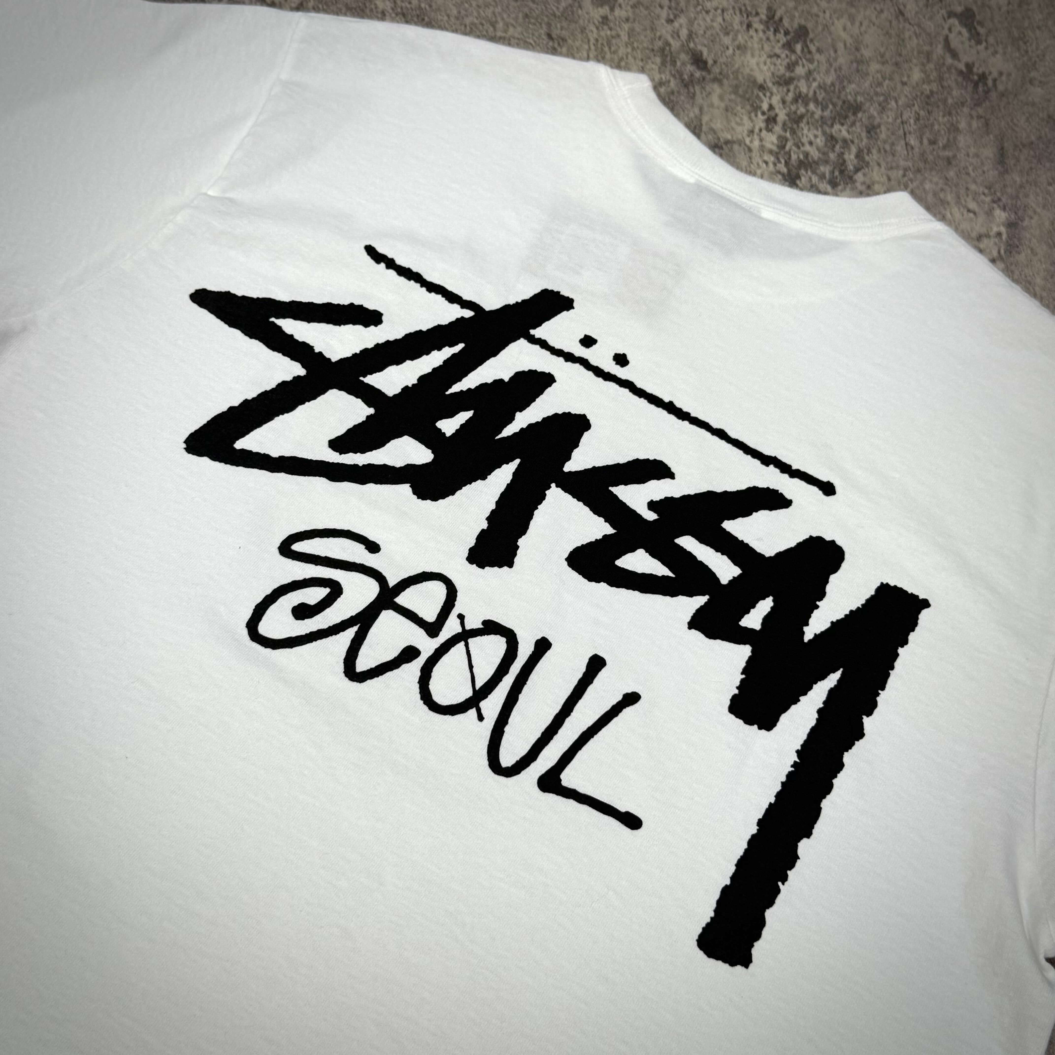 Stussy Seoul logo on the back of a white tee shirt showcasing exclusive design elements.