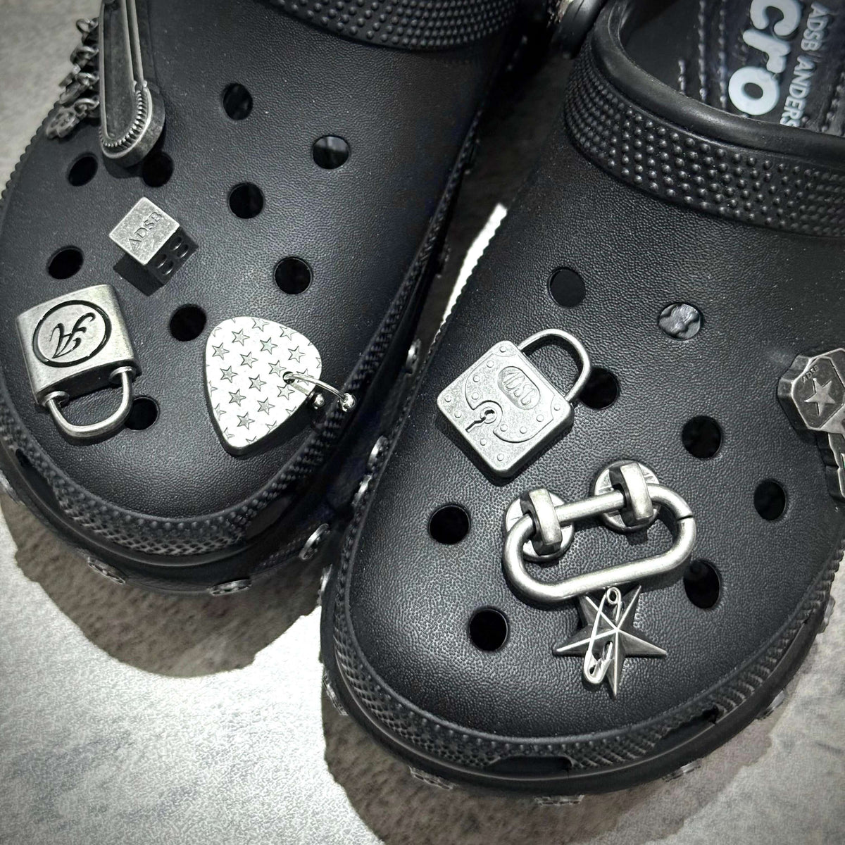 Close-up of ANDERSSON BELL x Crocs Bae Clog featuring decorative charms on black clogs.