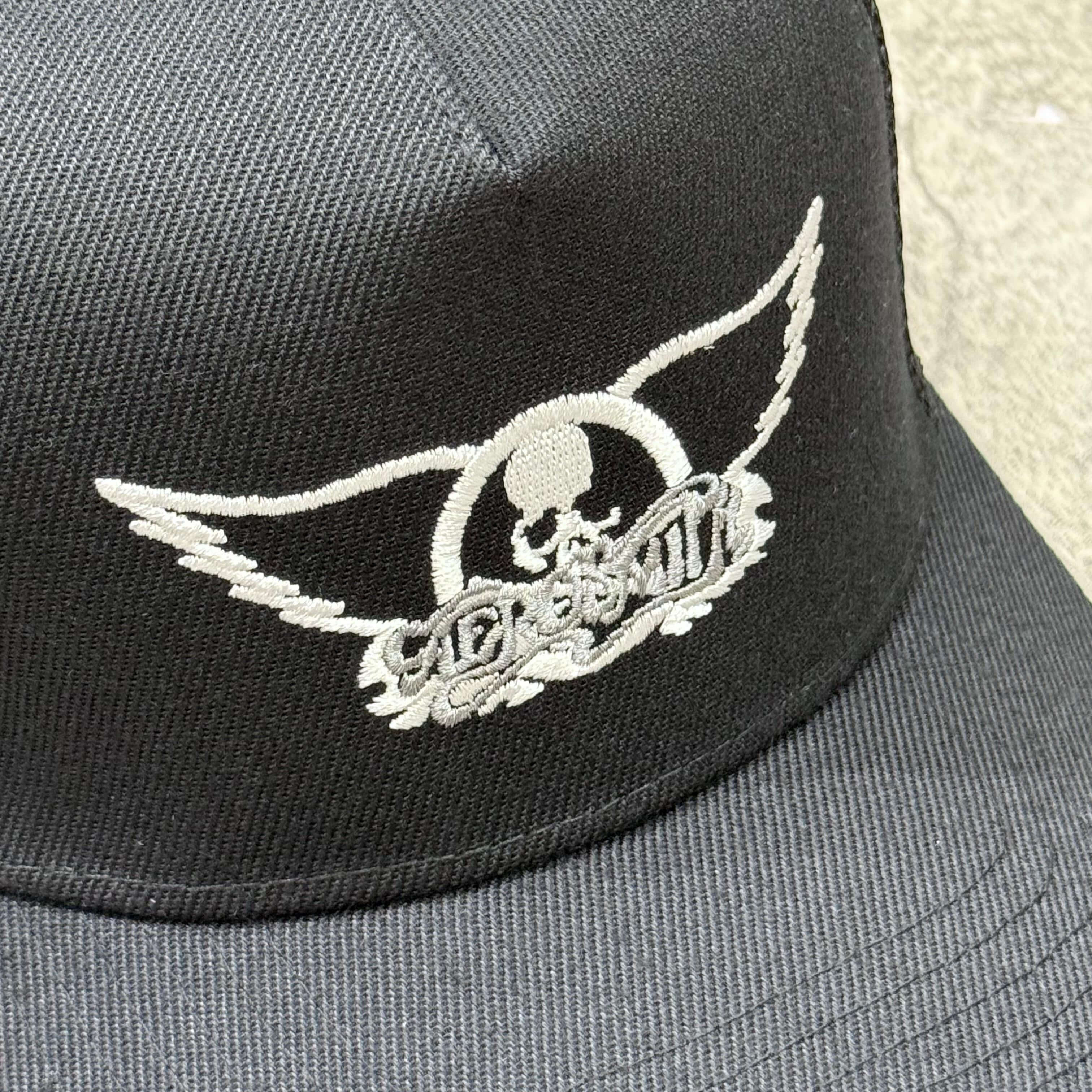 Aerosmith x Mastermind World Wing And Skull Logo Cap featuring iconic wing and skull logo embroidered on a black cap.