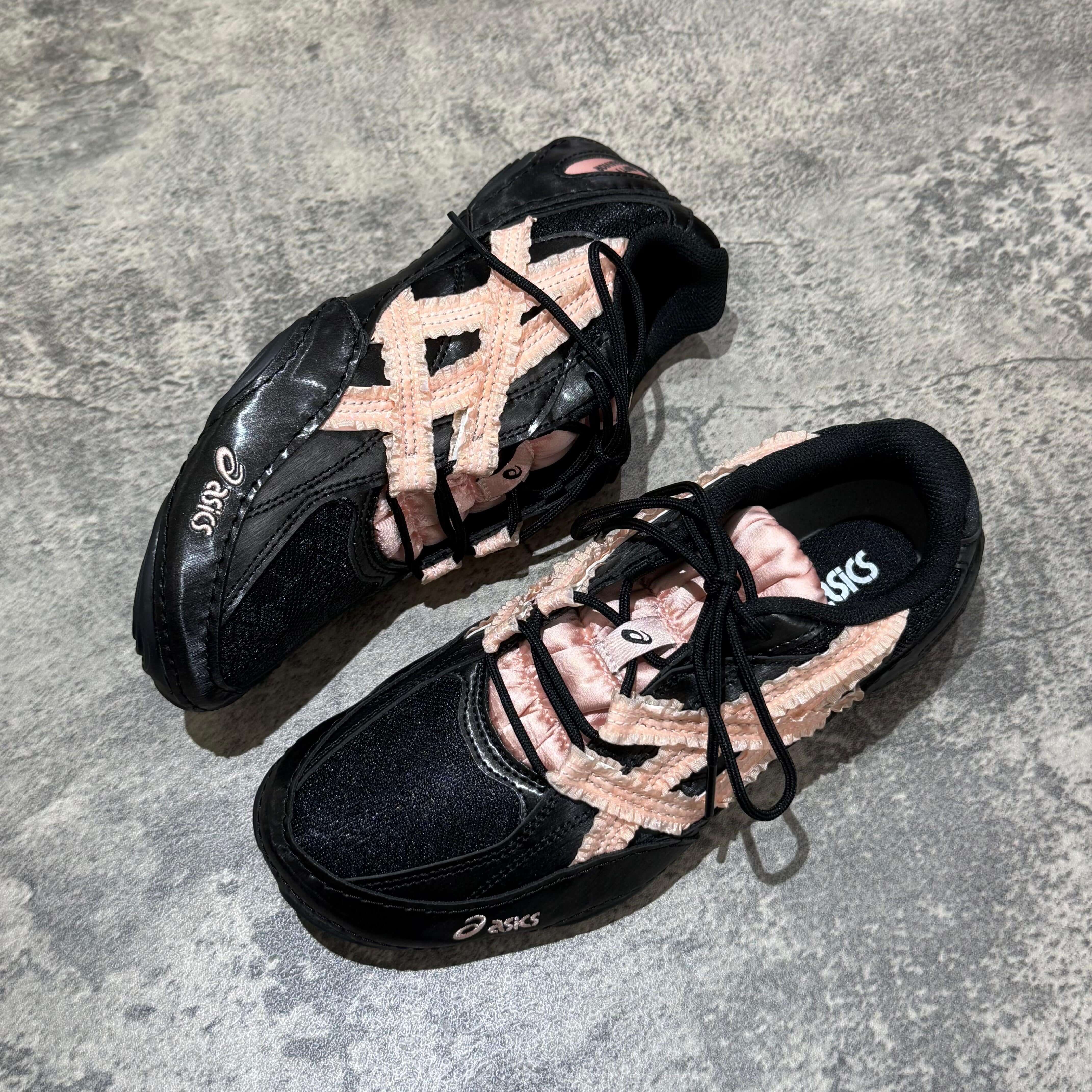 Asics x Empty Behavior Hypersync - Black Breeze sneakers featuring black and pink design on a textured surface.