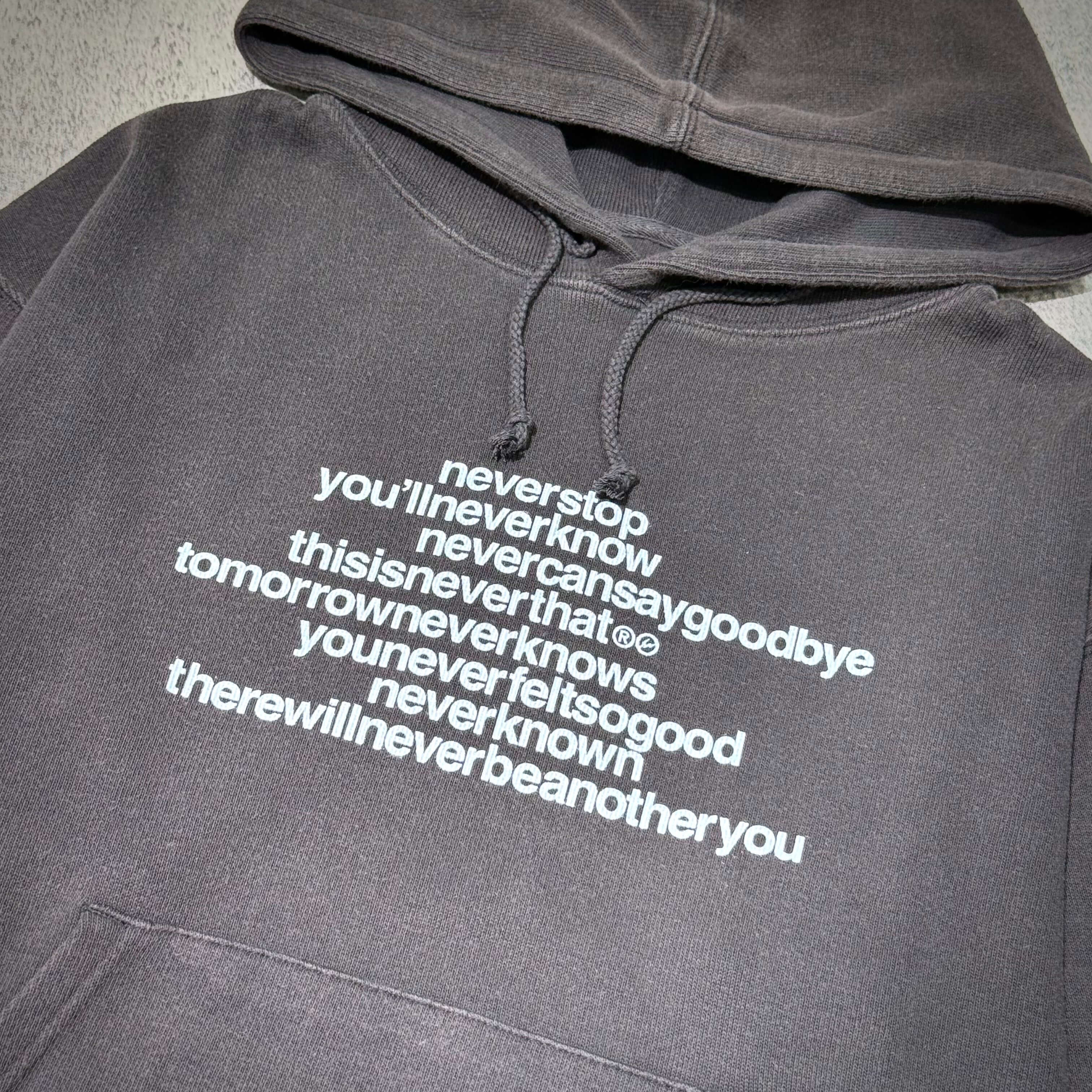 thisisneverthat x Fragment Design Hoodie- Off Black with motivational text design in white on a dark background.