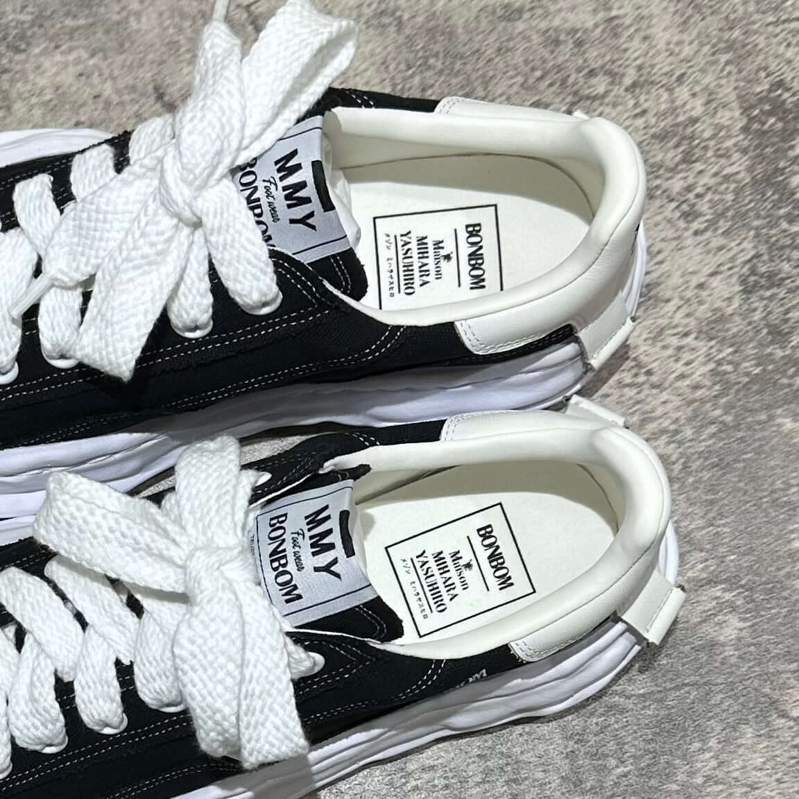 BONBOM x MMY BLAKEY OG Canvas - Black shoes with white laces and branded tags on a textured surface.