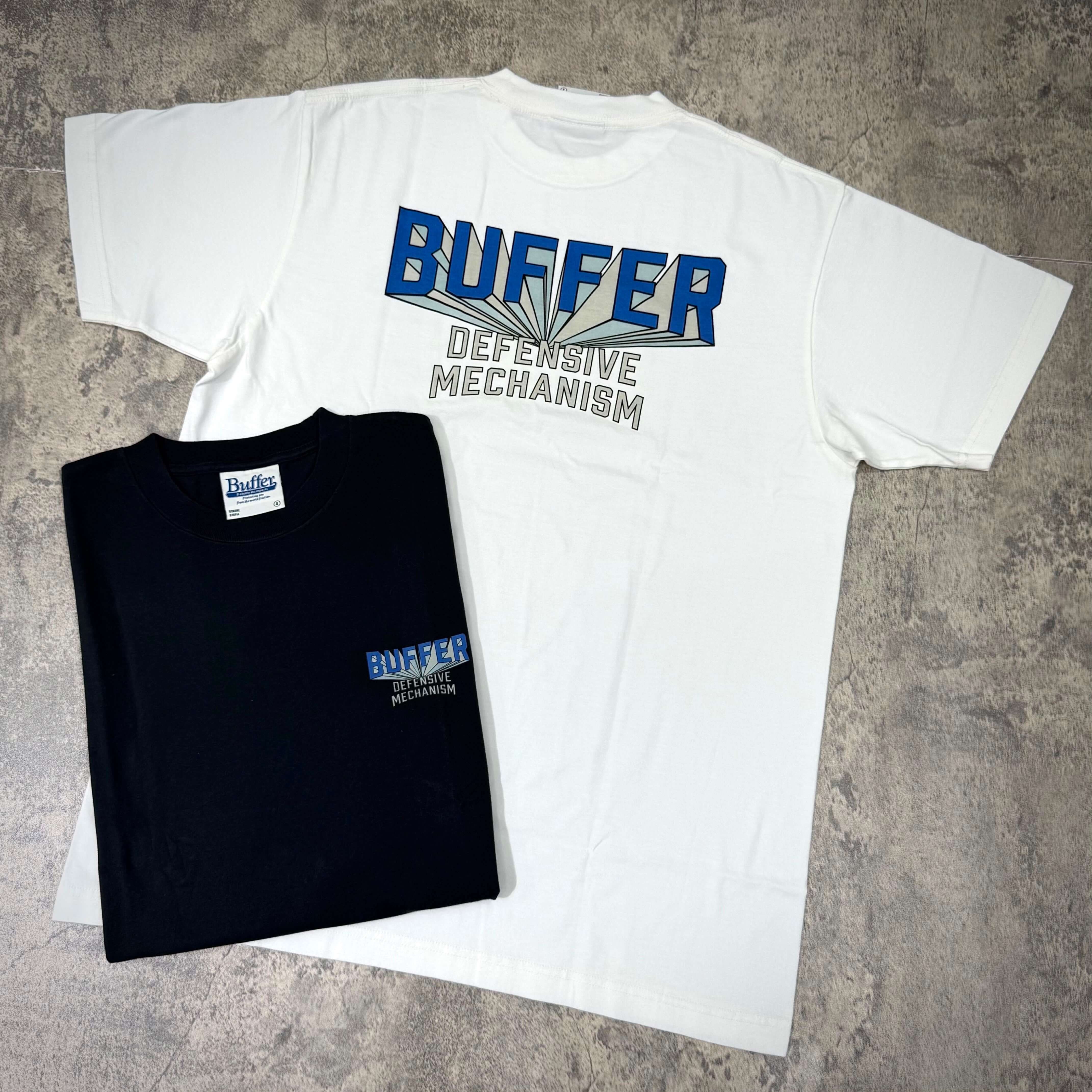 Buffer Gravity Tee - Black / White, featuring bold 'BUFFER DEFENSIVE MECHANISM' design in two colors.