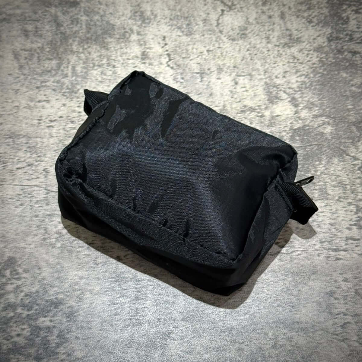 Human Made Travel Pouch in compact black design, perfect for organizing essentials while traveling.