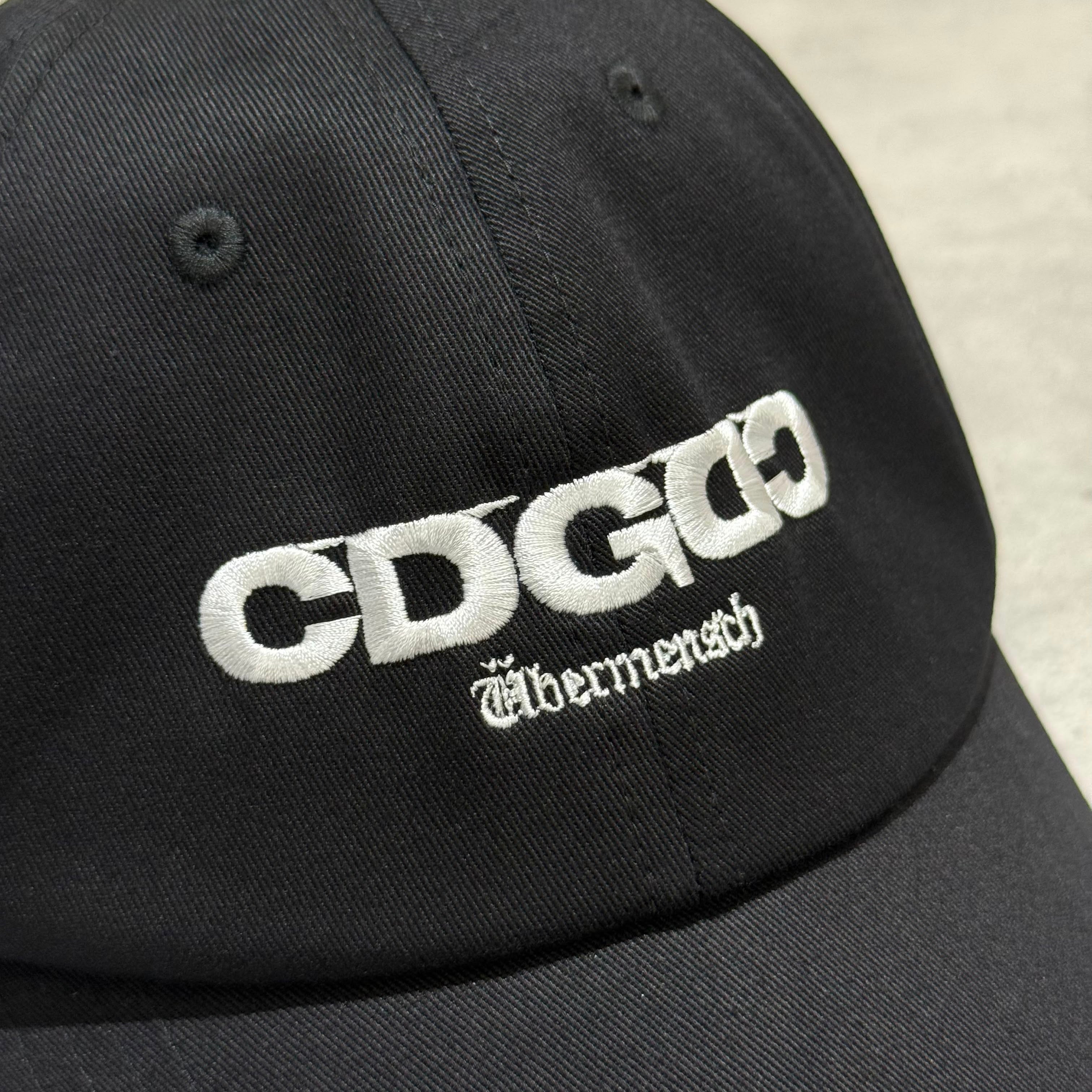 CDG x G-DRAGON Ubermensch Classic Cap featuring embroidered logo on a black cap.