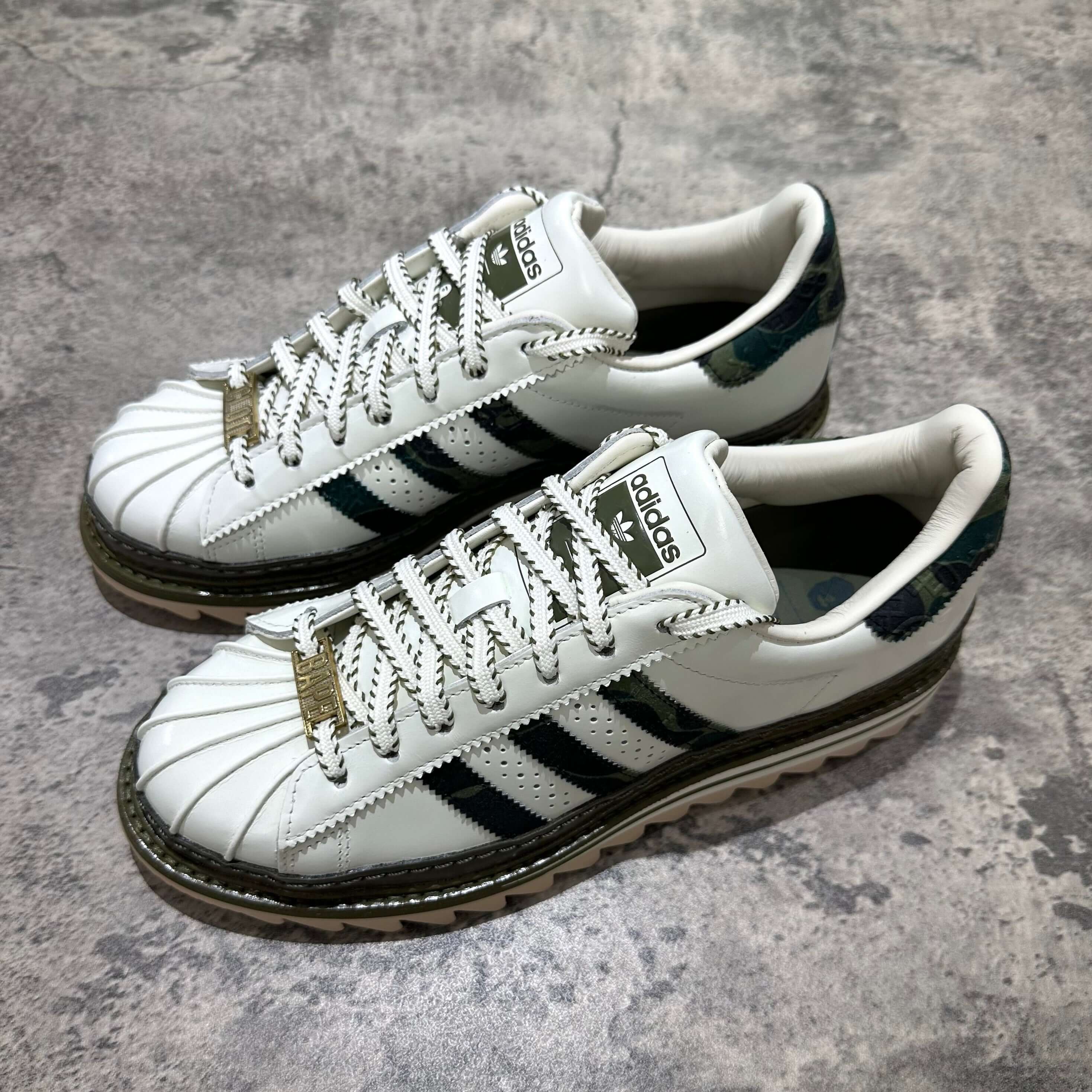現貨 CLOT x BAPE x Adidas Superstar,白色高幫運動鞋,獨特設計,鞋面有黑色條紋及中央金扣。