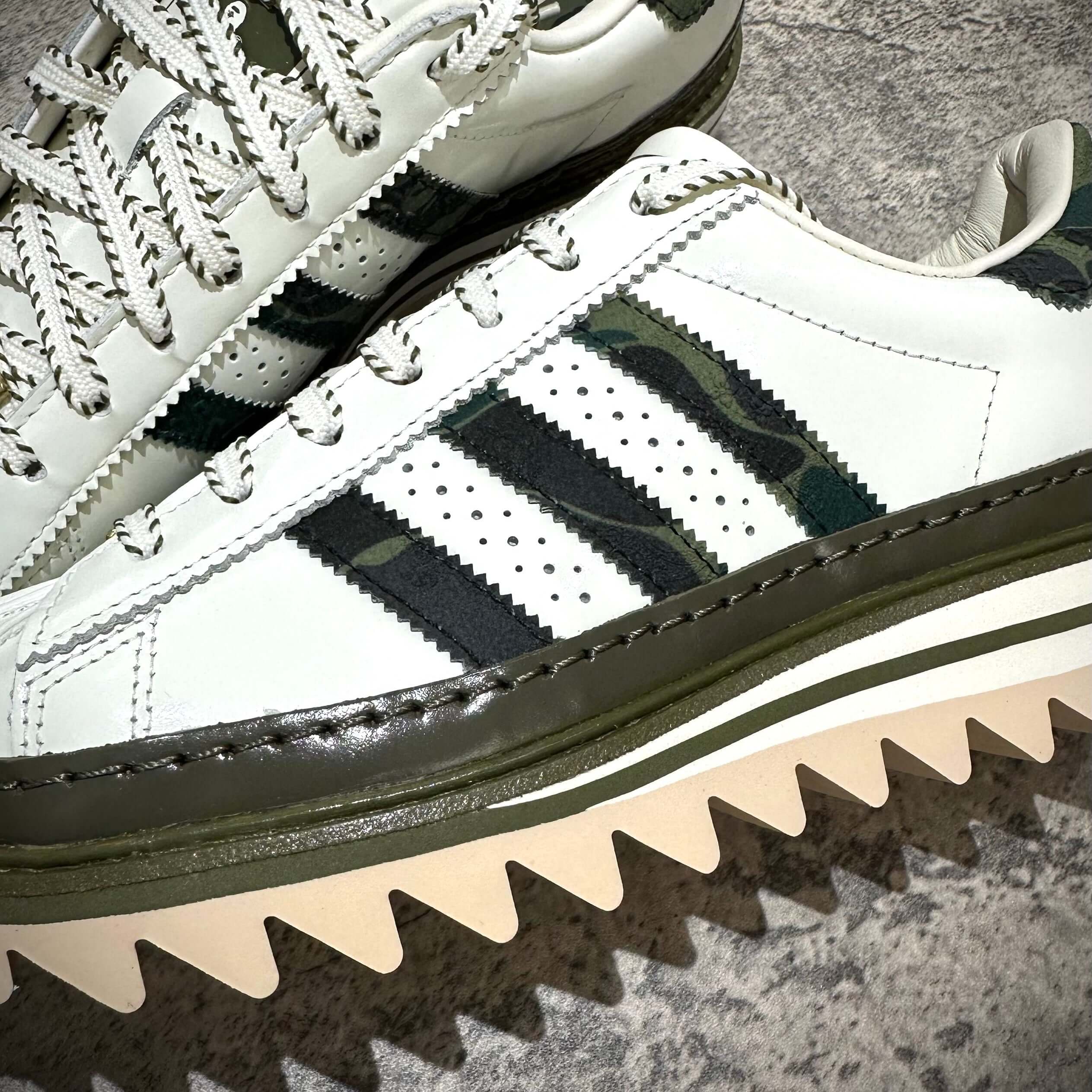 現貨 CLOT x BAPE x Adidas Superstar 鞋款特寫,展示綠色迷彩條紋和獨特鞋底設計