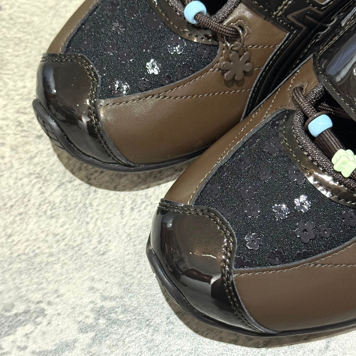 Cecilie Bahnsen x Asics Gel-Kinetic FR - Black Coffee 1203B171-001 close-up showing floral design and glossy accents.