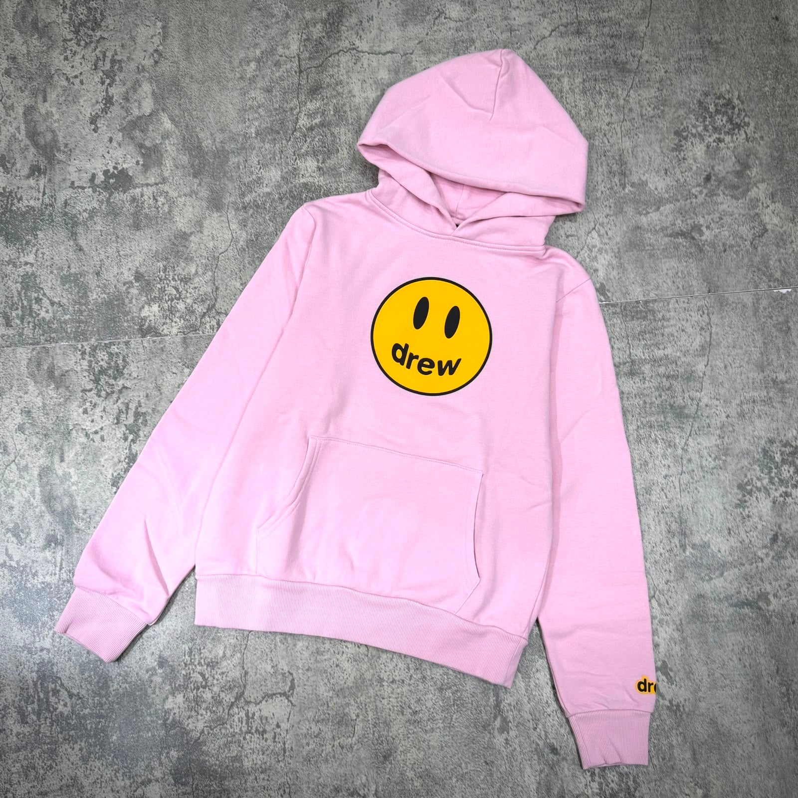 Drew House Mini drew Mascot Hoodie - Strawberry displayed on a textured background.