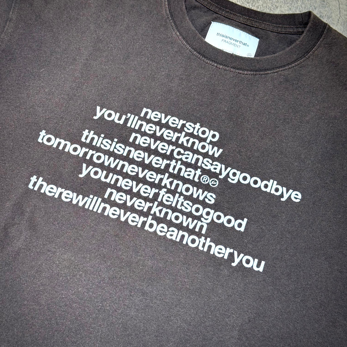thisisneverthat x Fragment Design Tee - Off Black with white text graphics on a dark background