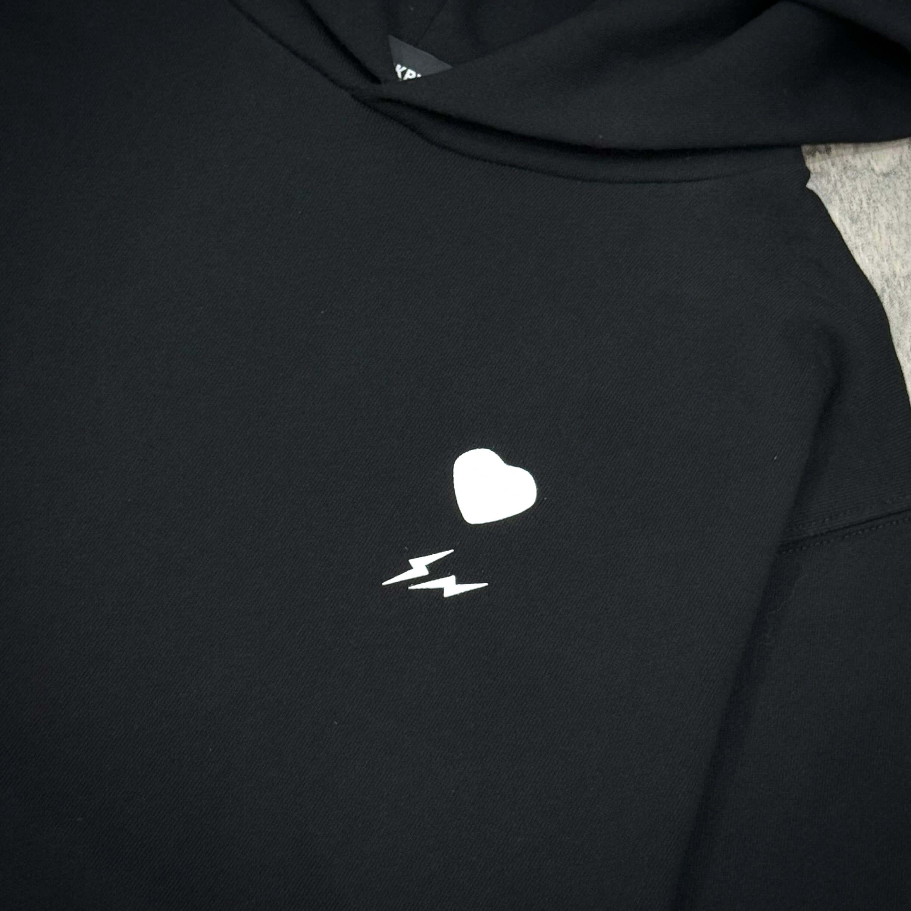 Fragment x Blackpink BLACKFRGMT Hoodie featuring a heart and lightning bolt design in white on a black background.