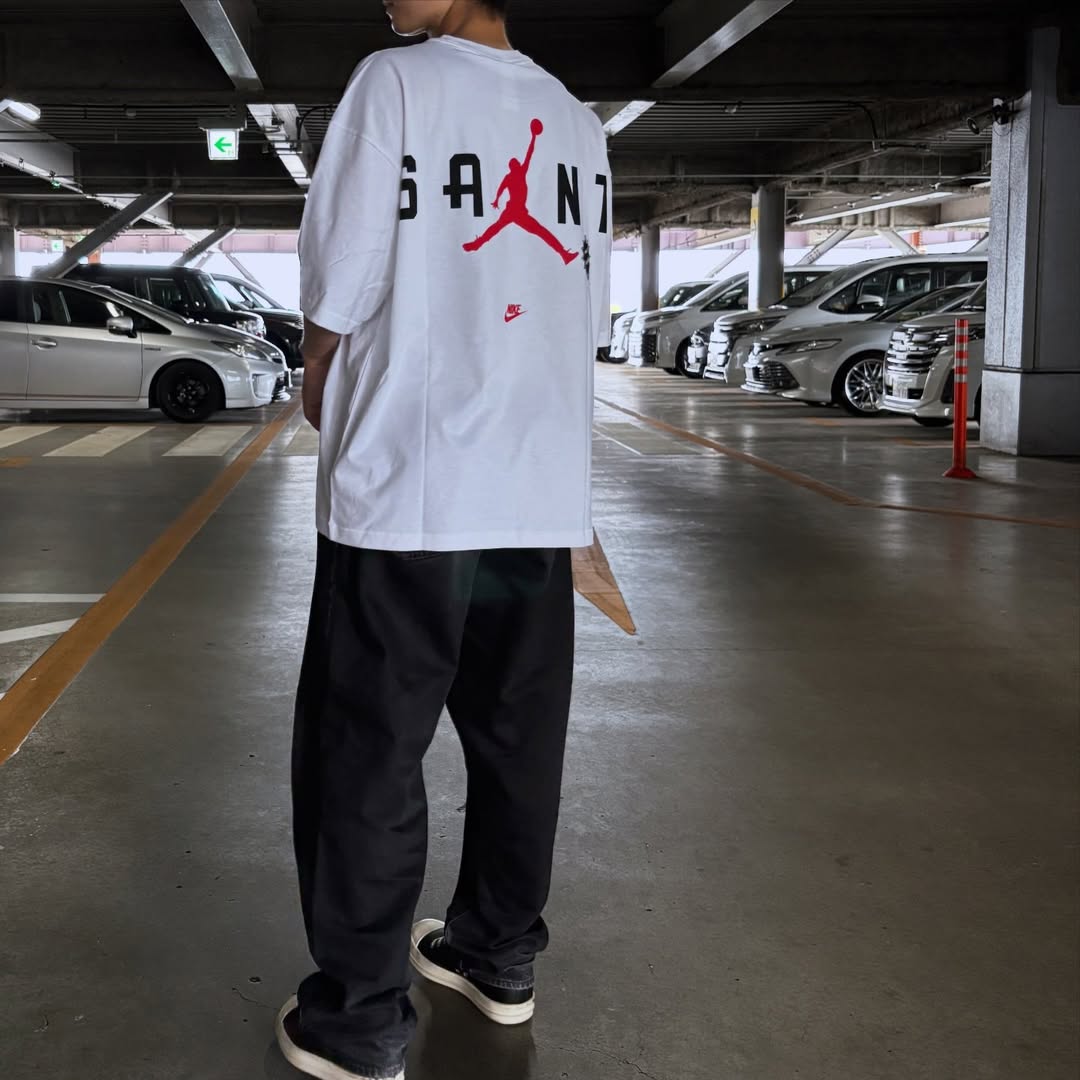 Saint Mxxxxxx Michael Jordan TIME CAPSULE Tee 於停車場的穿著展示,顯示其獨特設計和風格。