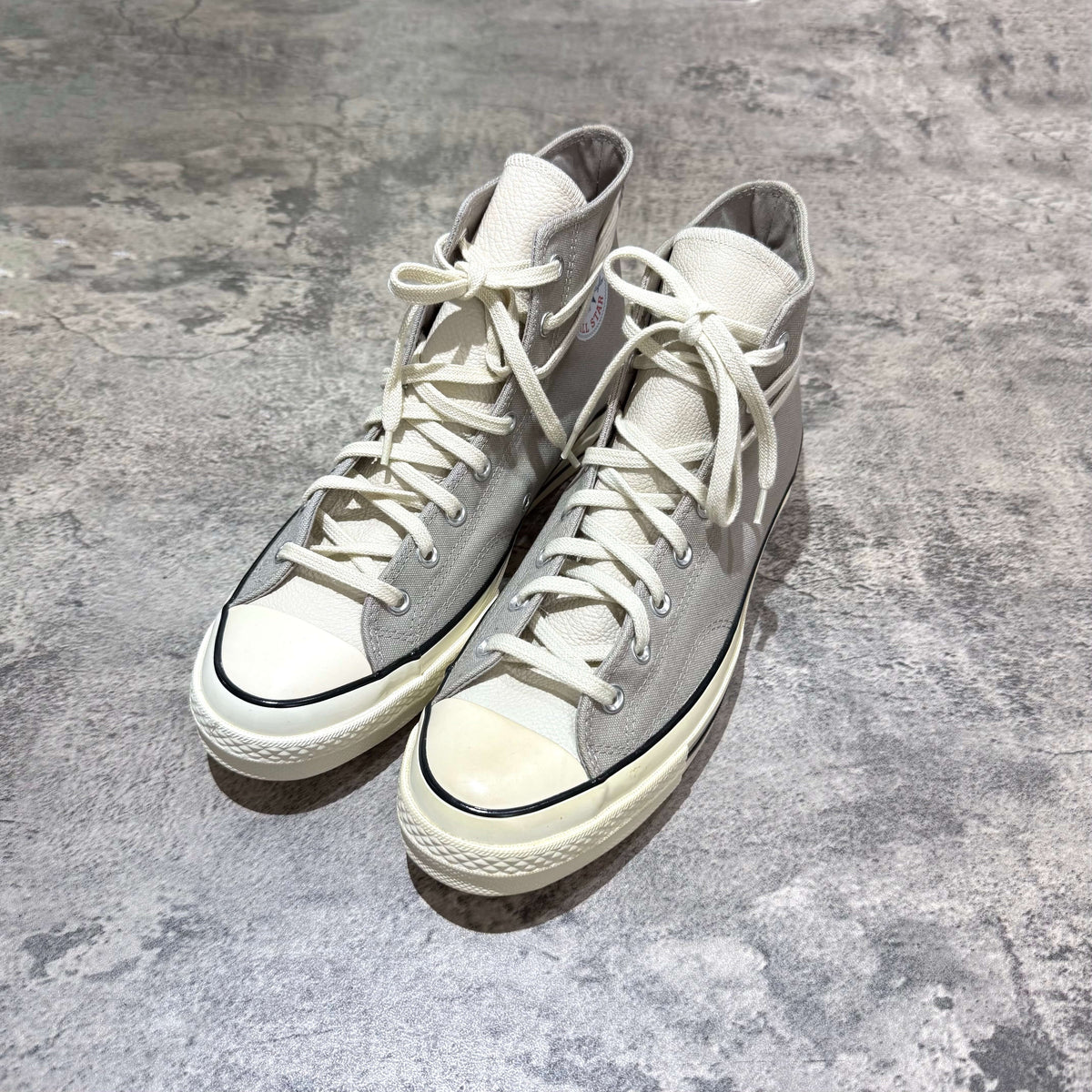 Fear Of God Essentials x Converse Chuck 70s Hi in white and grey, featuring high-top design and classic styling.