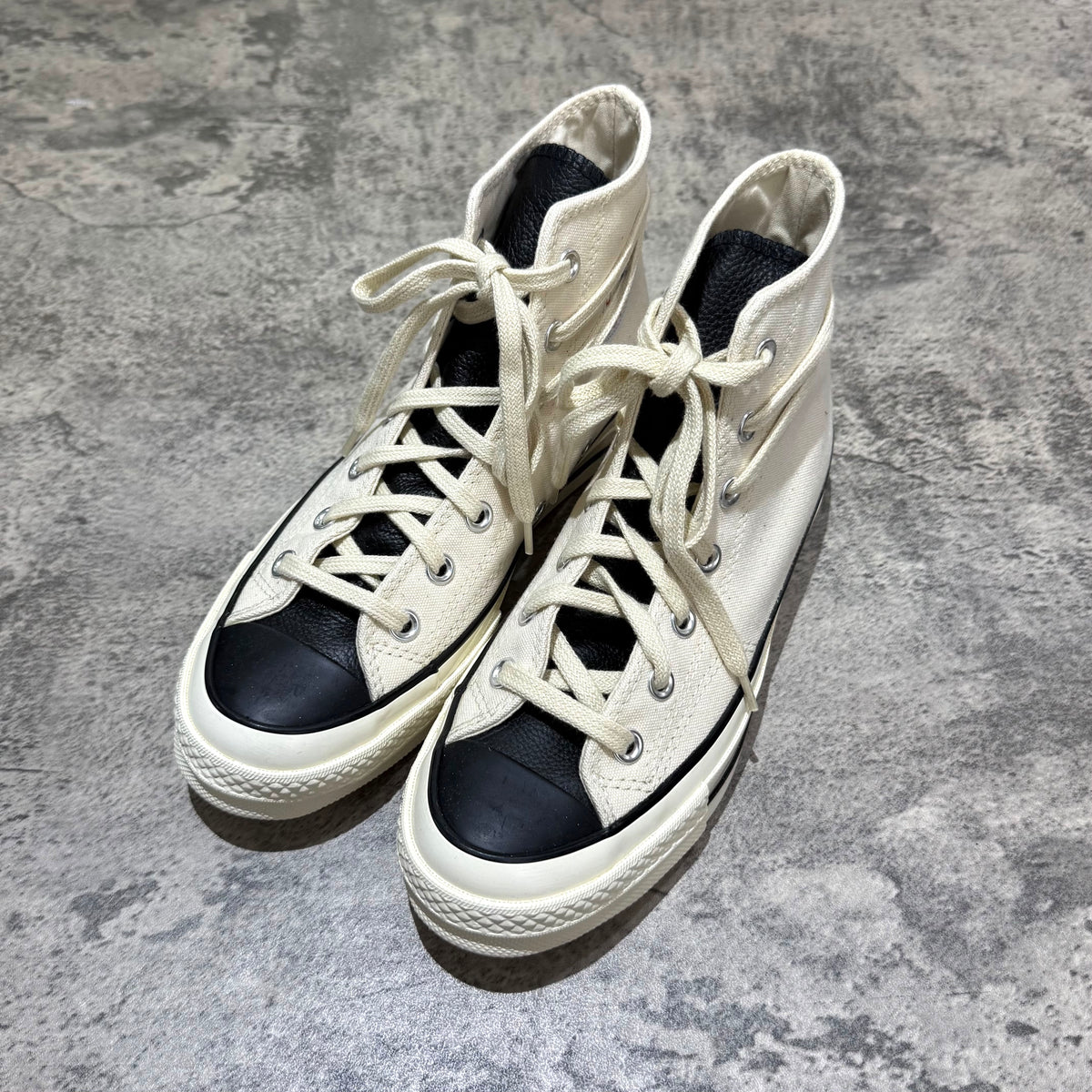 Fear Of God Essentials x Converse Chuck 70s Hi - White / Grey sneakers on a textured background.