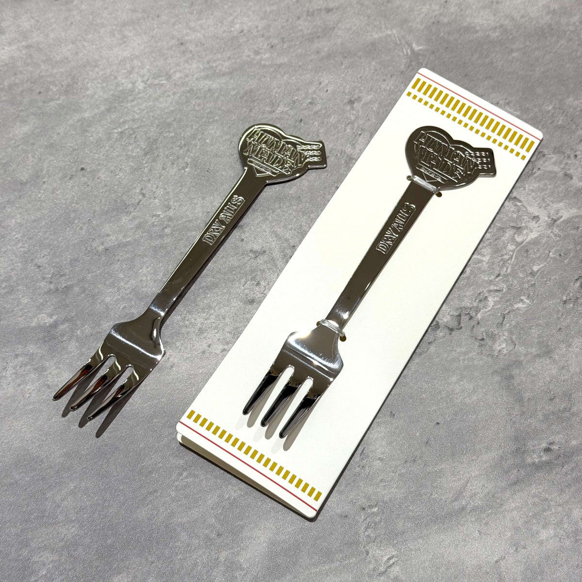Human Made Cup Noodle Fork in stainless steel, displayed with packaging on a textured surface.
