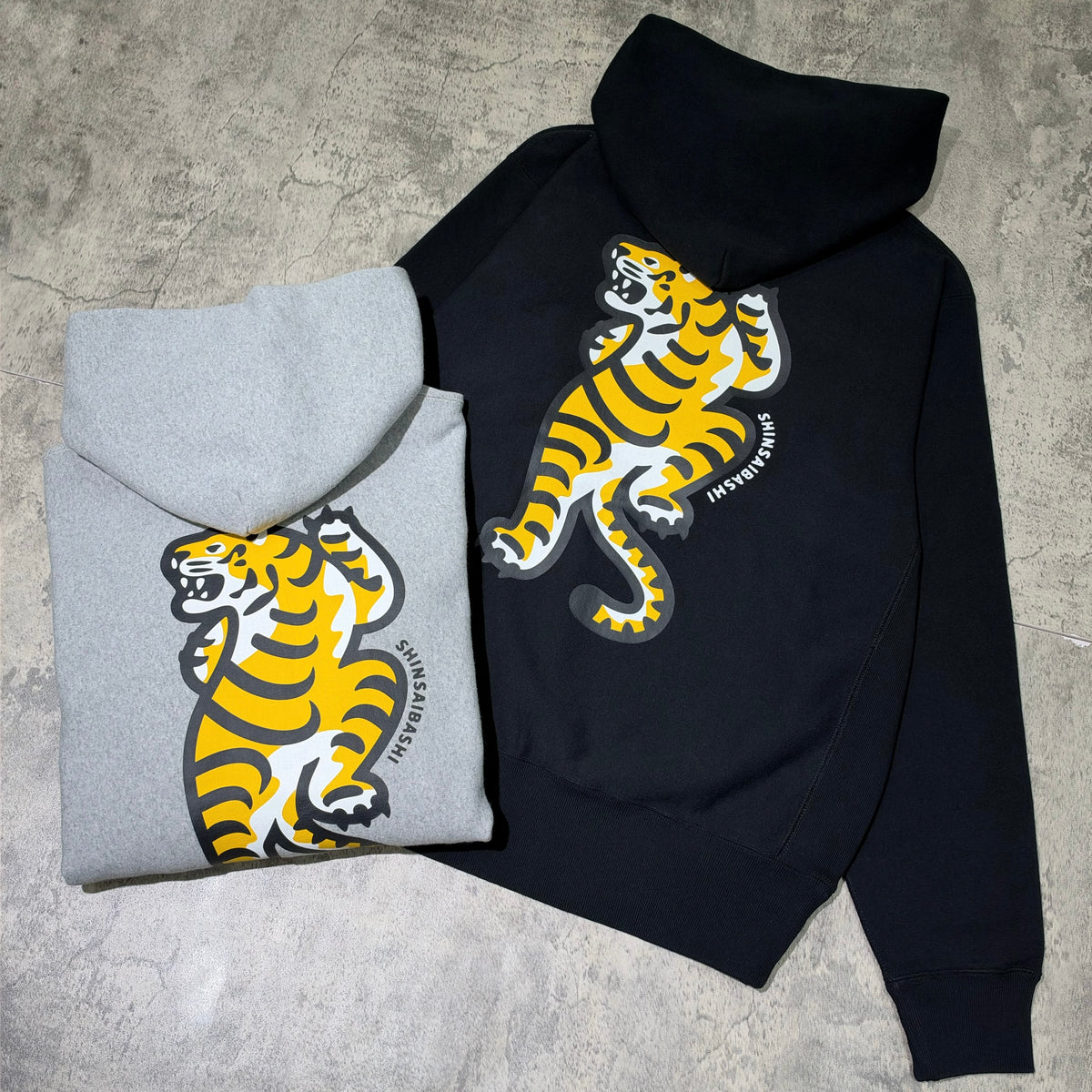Human Made Shinsaibashi Exclusive Tiger Heavyweight Hoodie in black and gray colors with tiger graphic on the back.