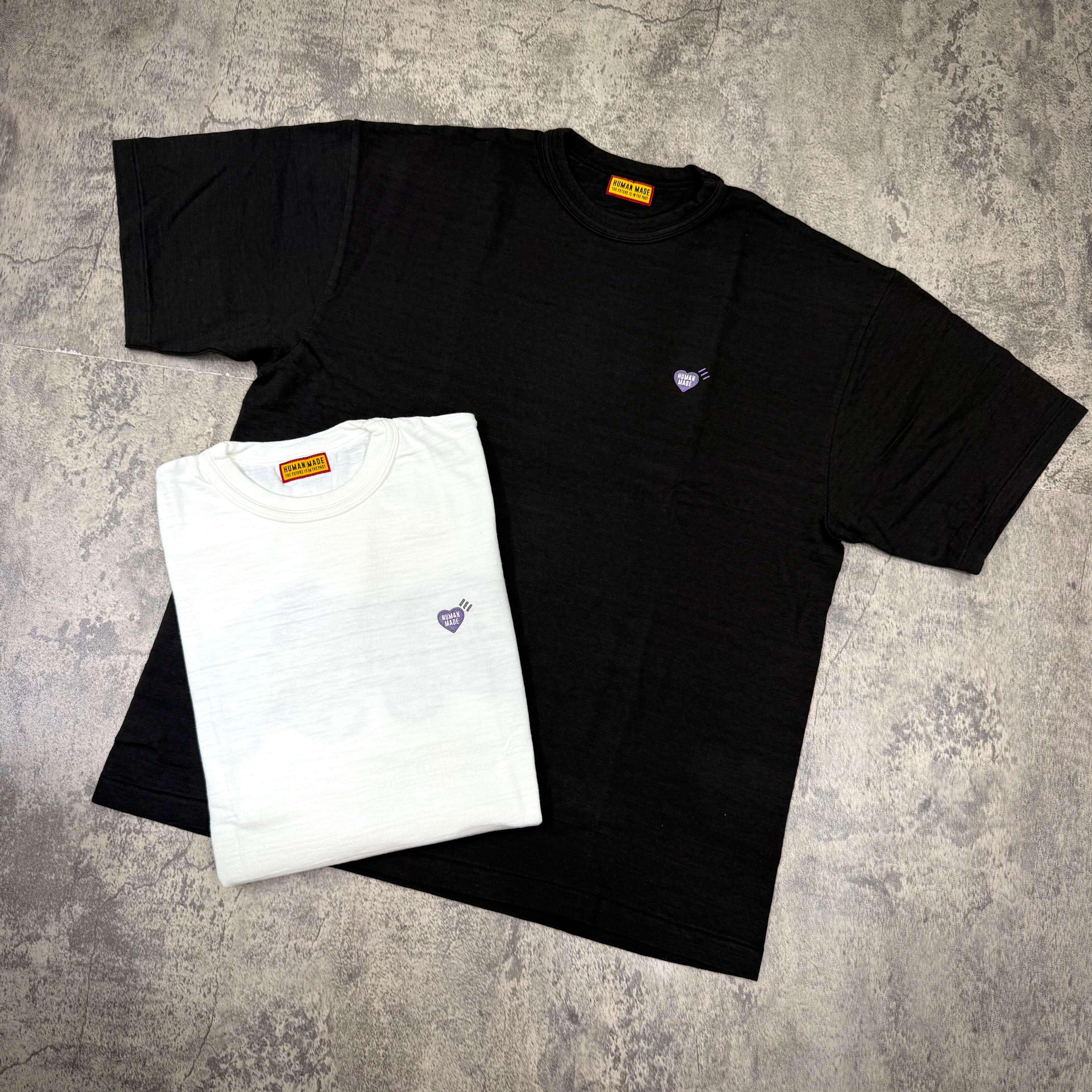 Human Made Apgujeong Exclusive Leopard Back Logo Tee in black and white displayed on a textured surface.