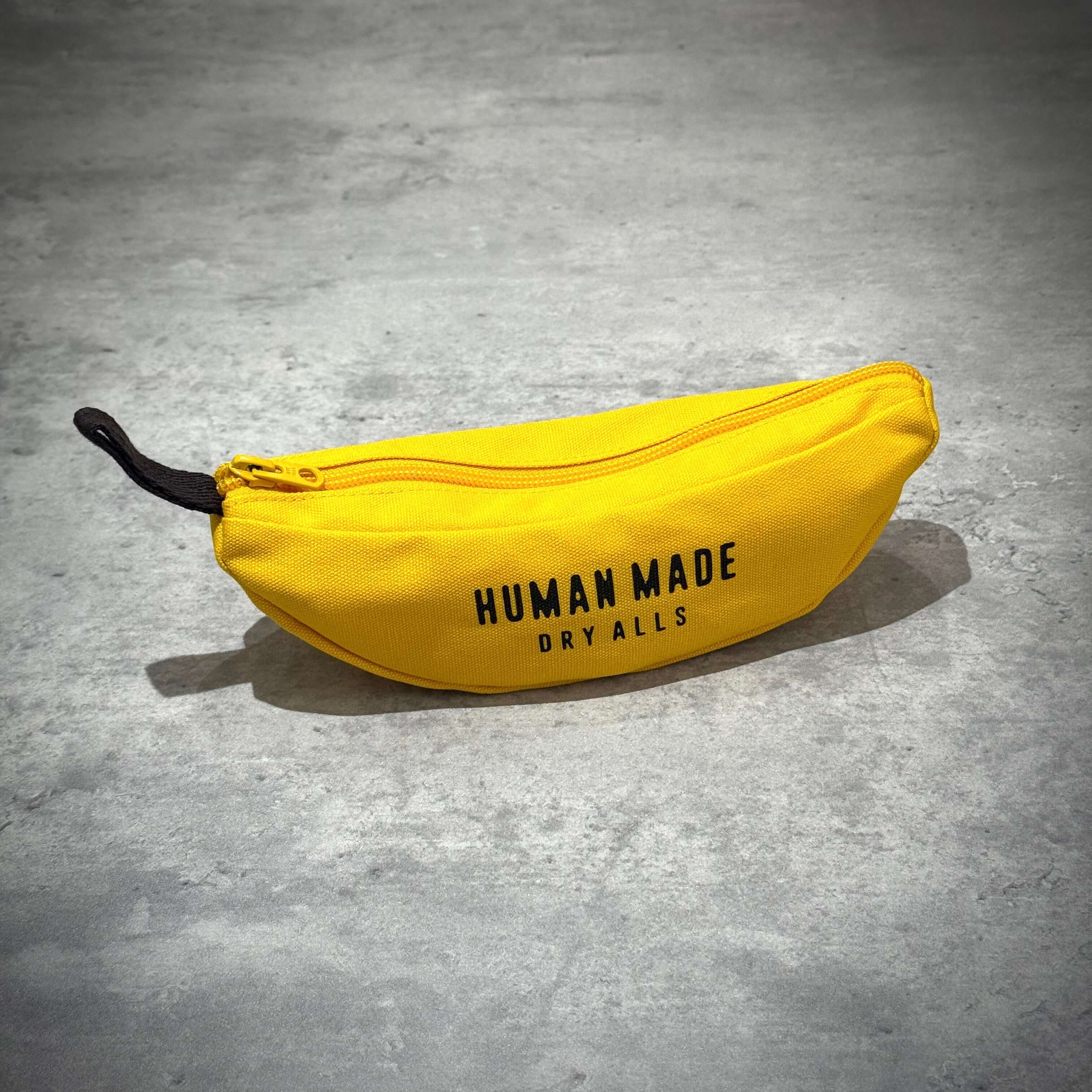 Human Made Banana Pouch in yellow, zippered design featuring 'HUMAN MADE DRY ALLS' text.