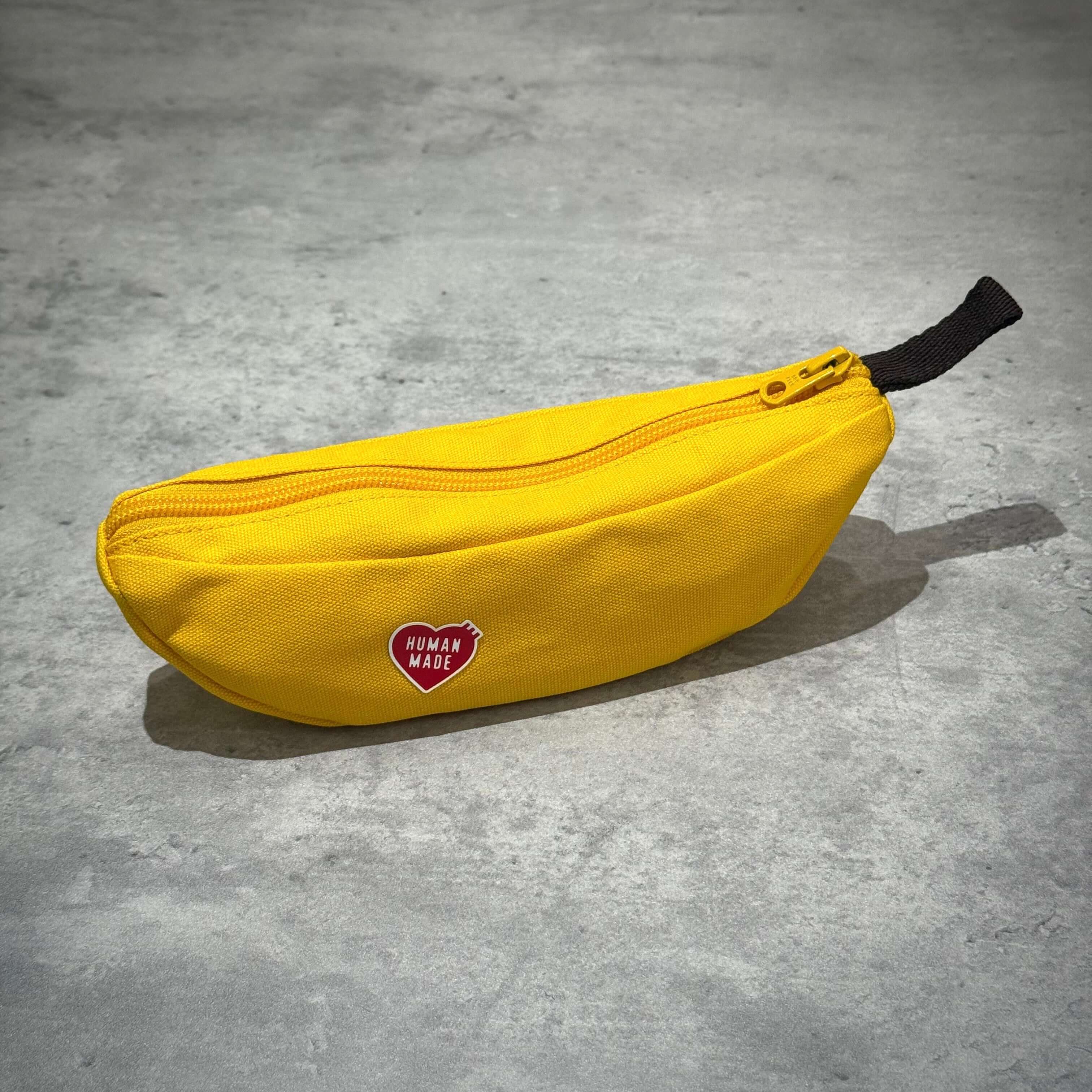 Human Made Banana Pouch in vibrant yellow color with a zipper and red logo.