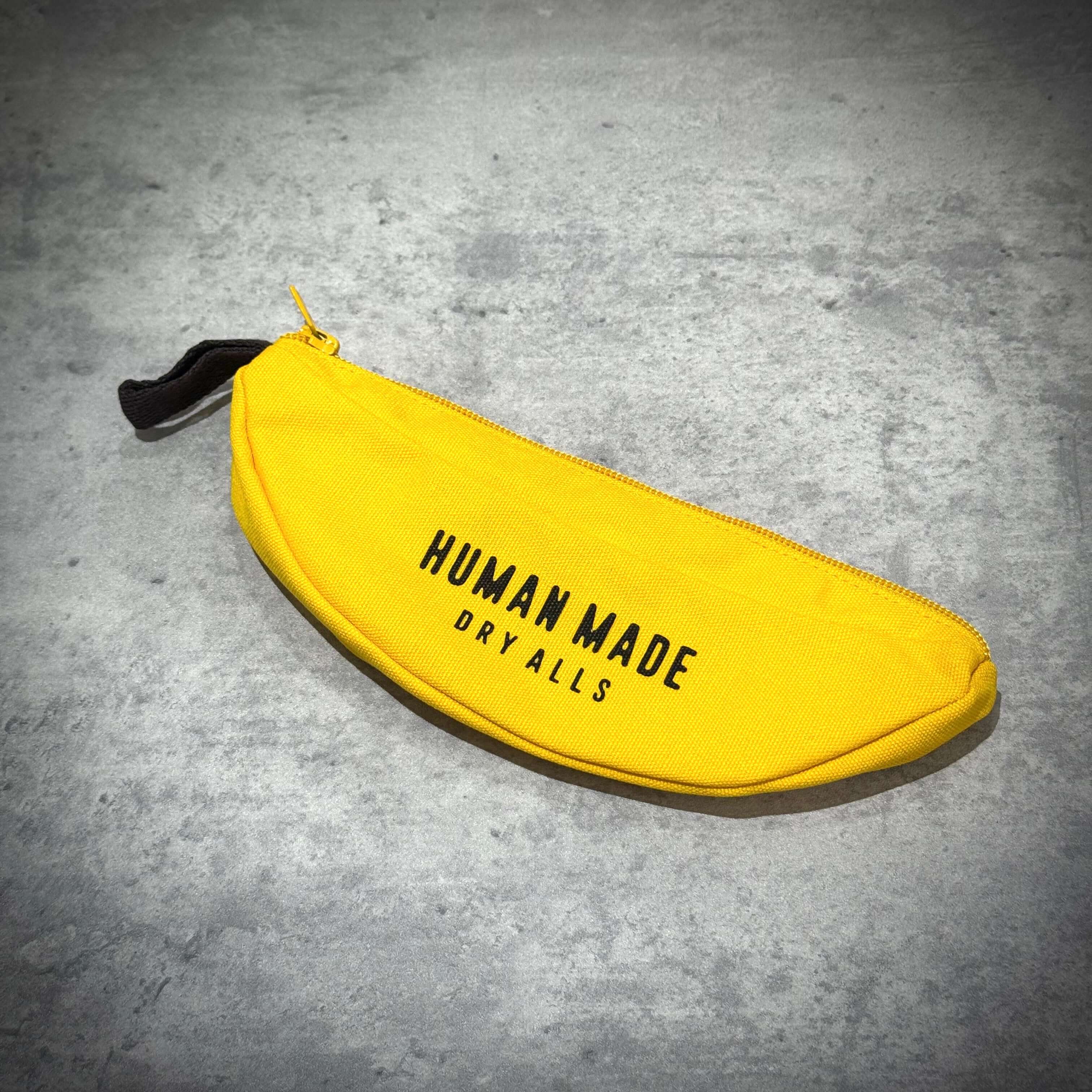 Human Made Banana Pouch in vibrant yellow with black lettering, perfect for stylish storage.