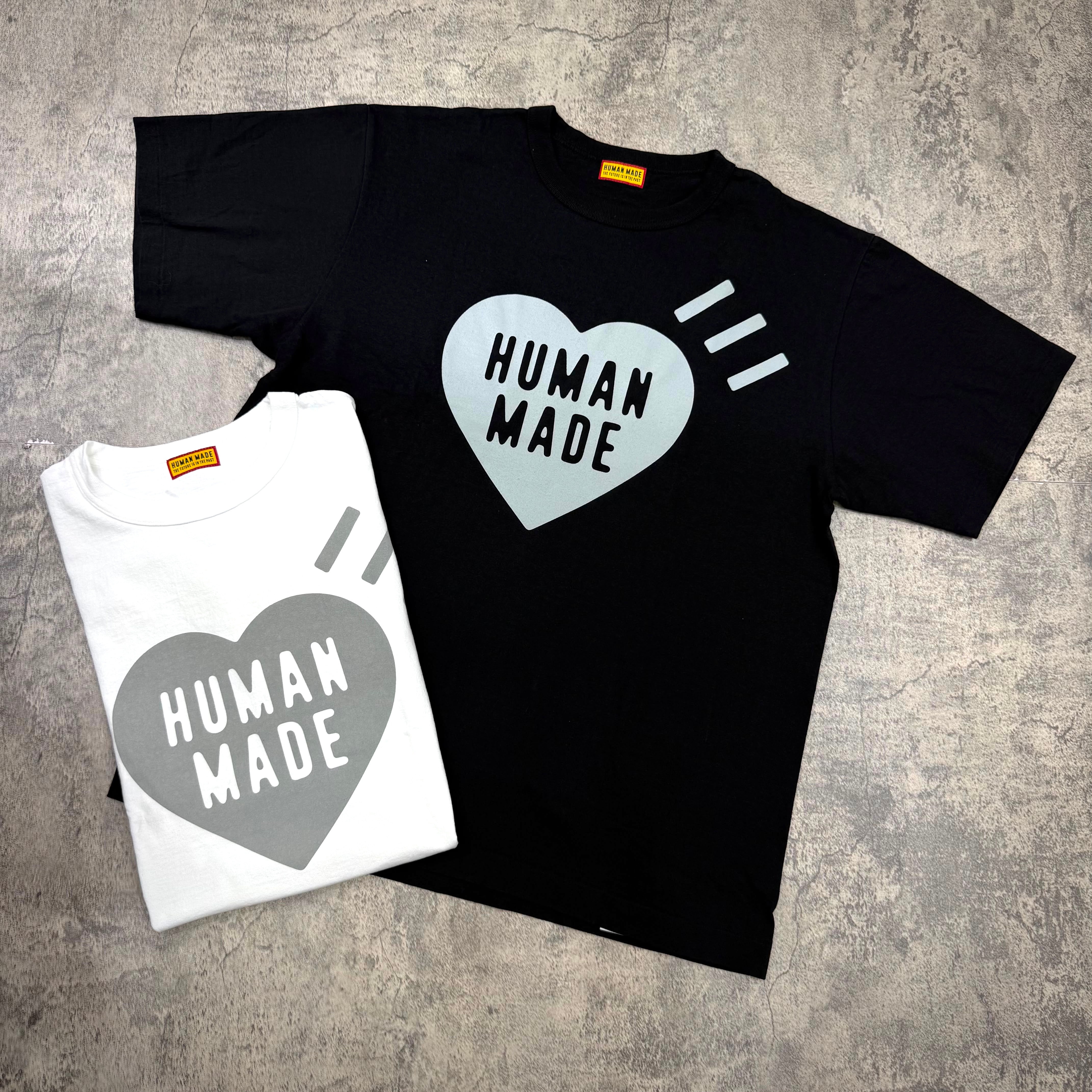 Human Made Sapporo Exclusive Heart Logo Tee in black and white displayed on a textured background.
