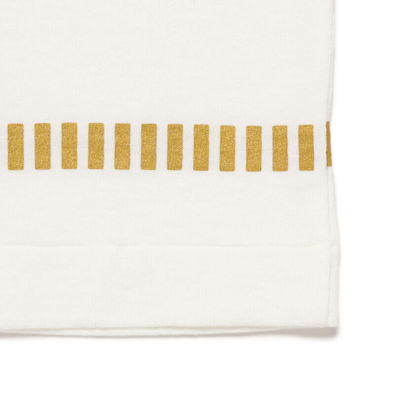 Close-up of the Human Made Cup Noodle Graphic Tee detailing, featuring a gold stripe pattern on white fabric.