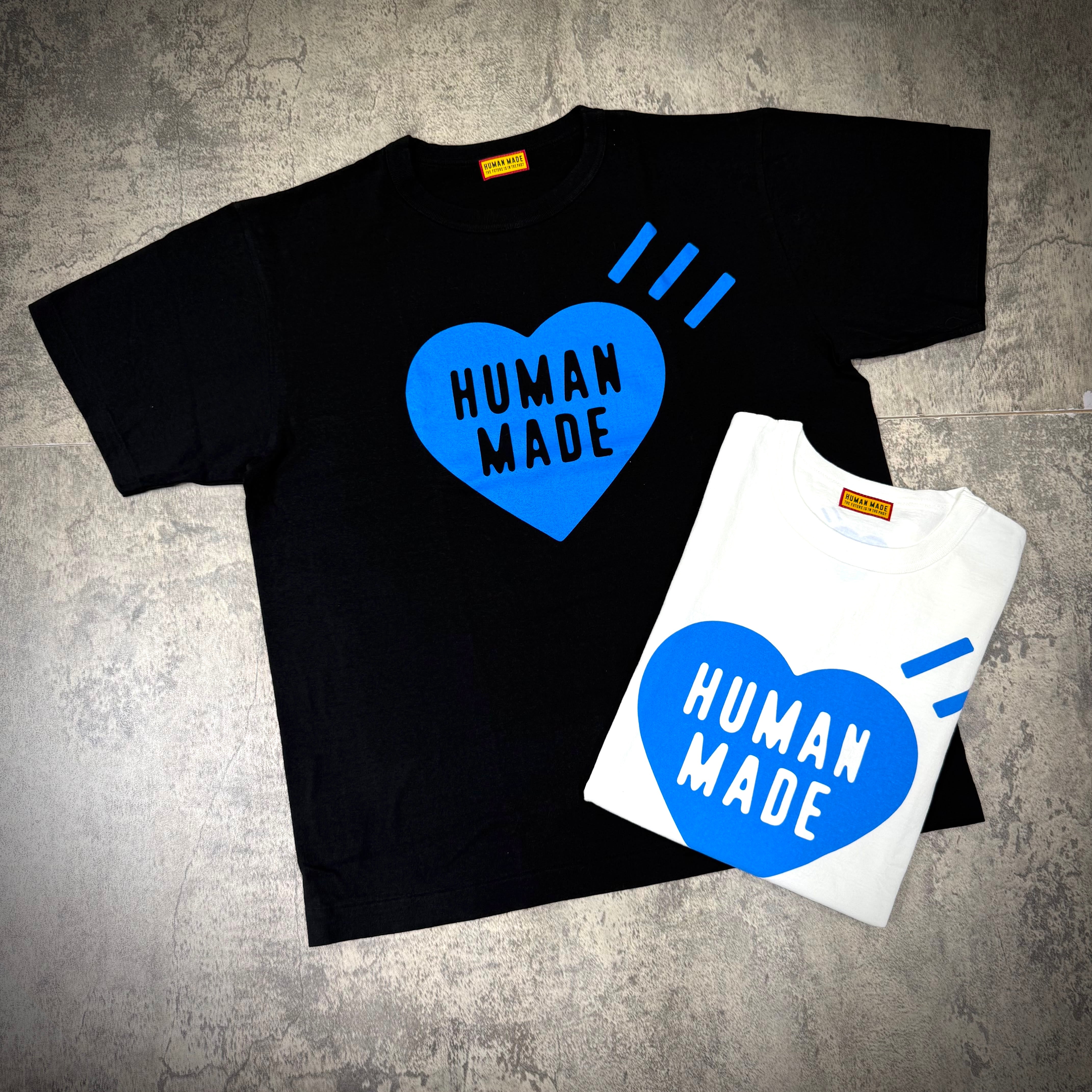 Human Made Gaien offline Exclusive Heart Logo Tee - black and white t-shirts displaying heart logo and brand name.