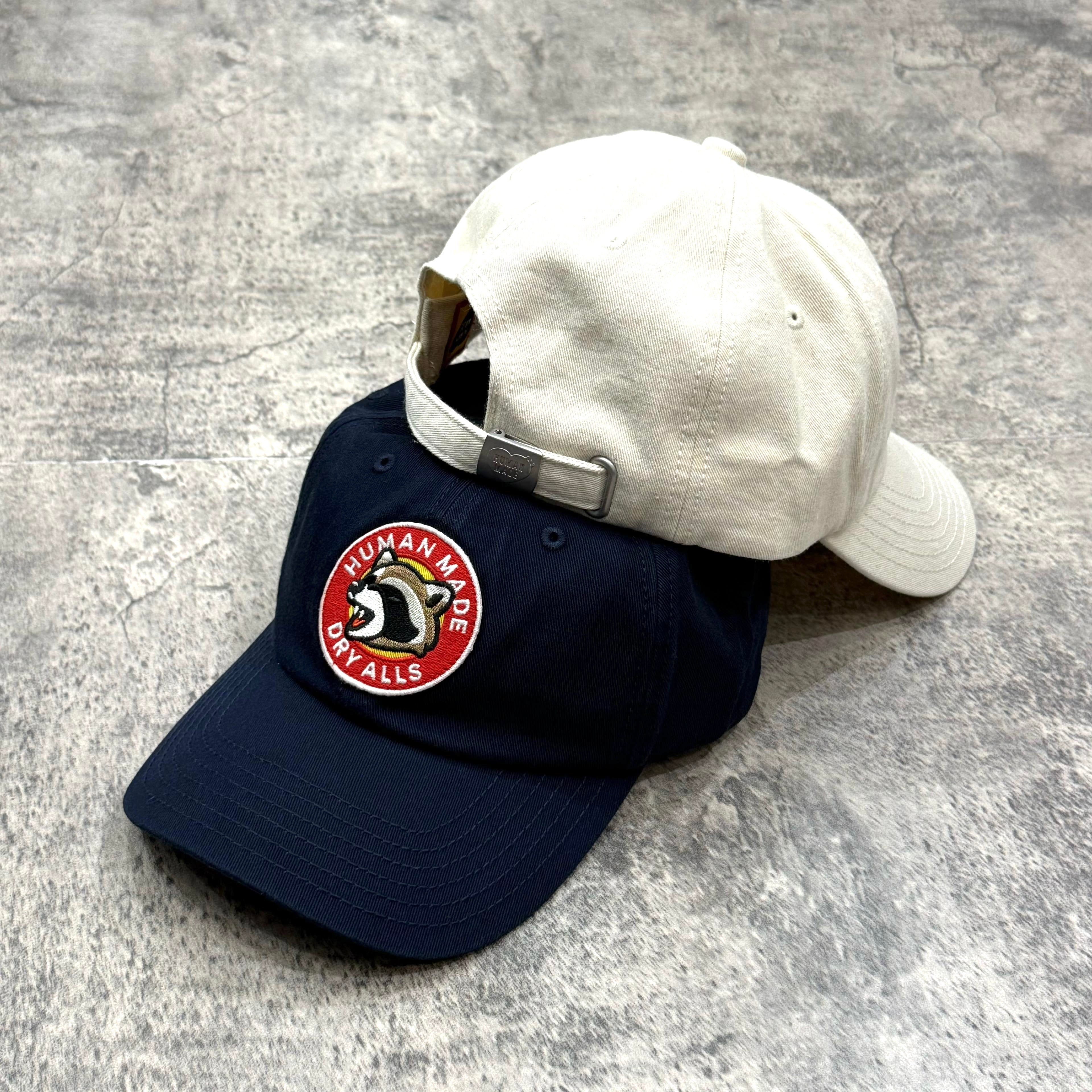 Human Made Jamsil Exclusive 6 Panel Twill Raccon Cap in navy and white, featuring a circular logo patch on front.