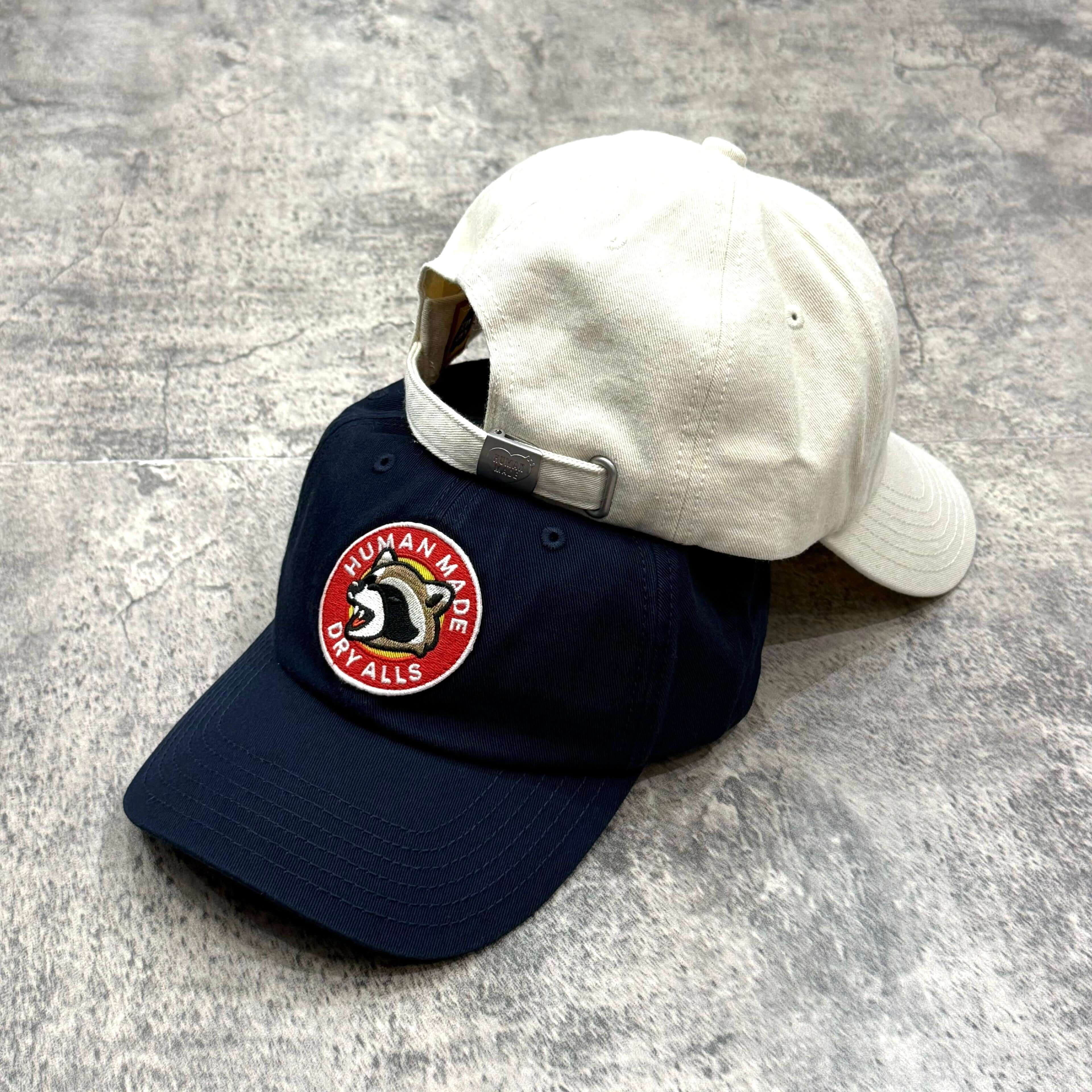 Human Made Jamsil Exclusive 6 Panel Twill Raccon Cap in navy and white, featuring a circular logo patch on front.