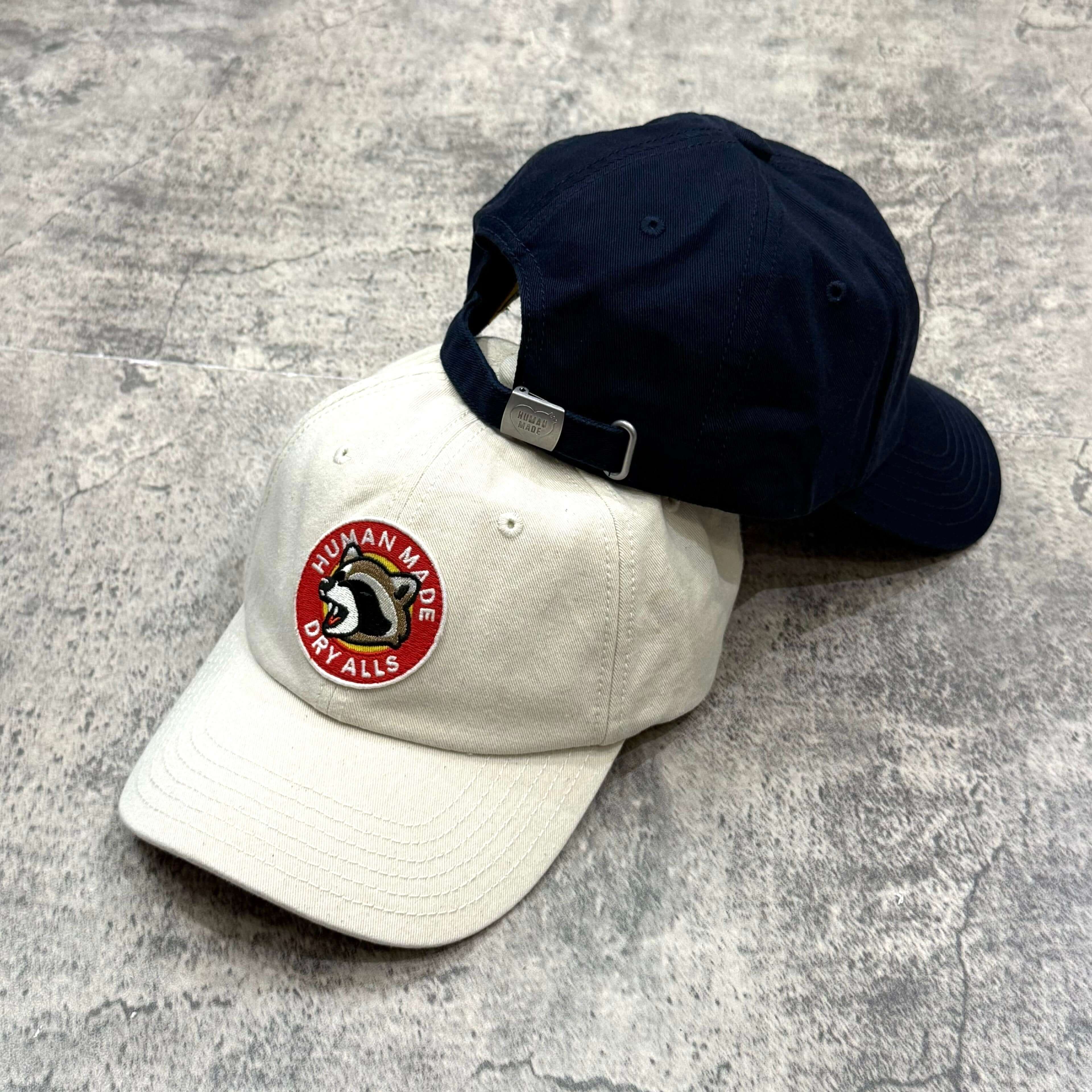 Human Made Jamsil Exclusive 6 Panel Twill Raccon Cap displayed in white and navy color options.