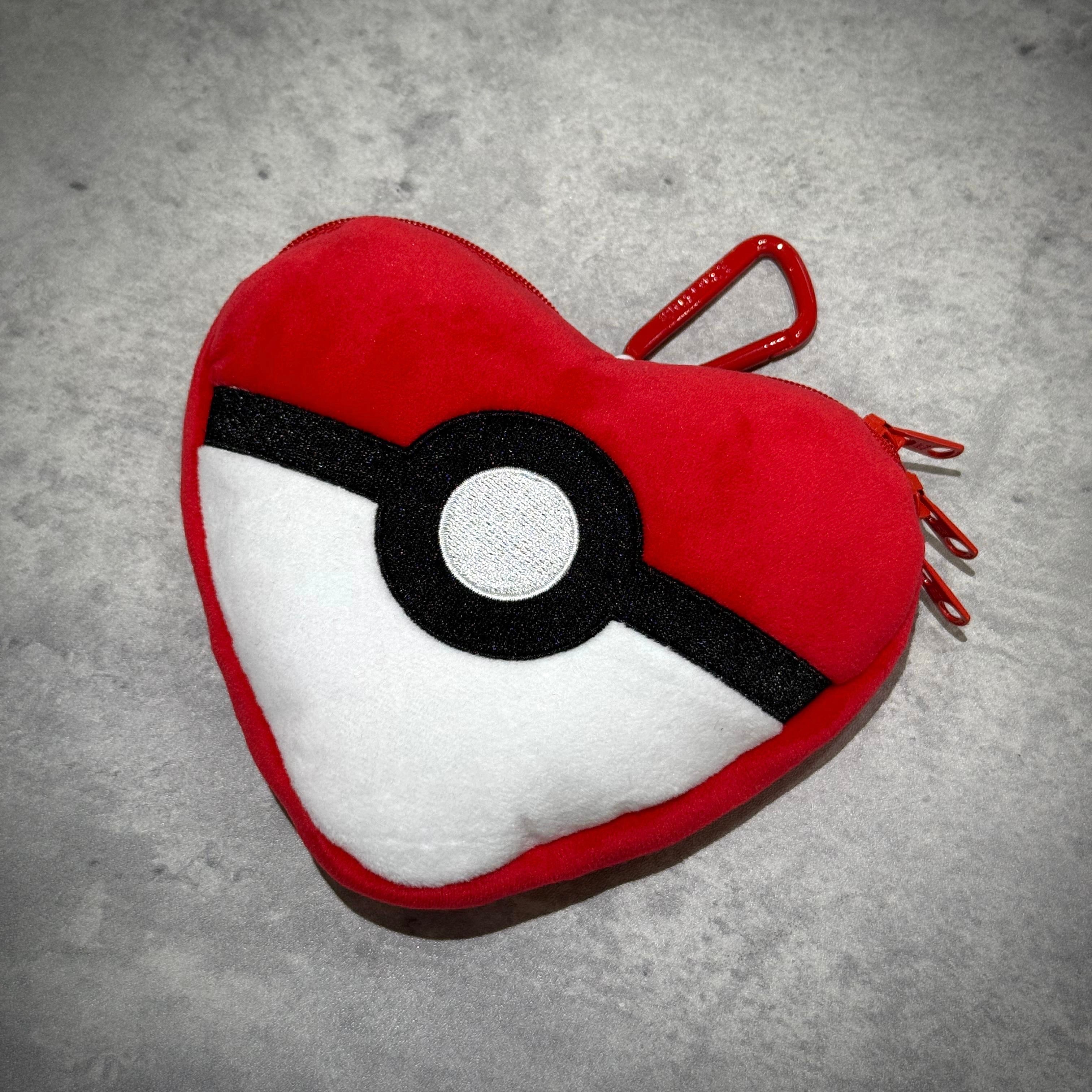 Human Made x Pokemon Heart Stuffed Passcase, red heart pouch with Pokeball design, ideal for storing cards and essentials.