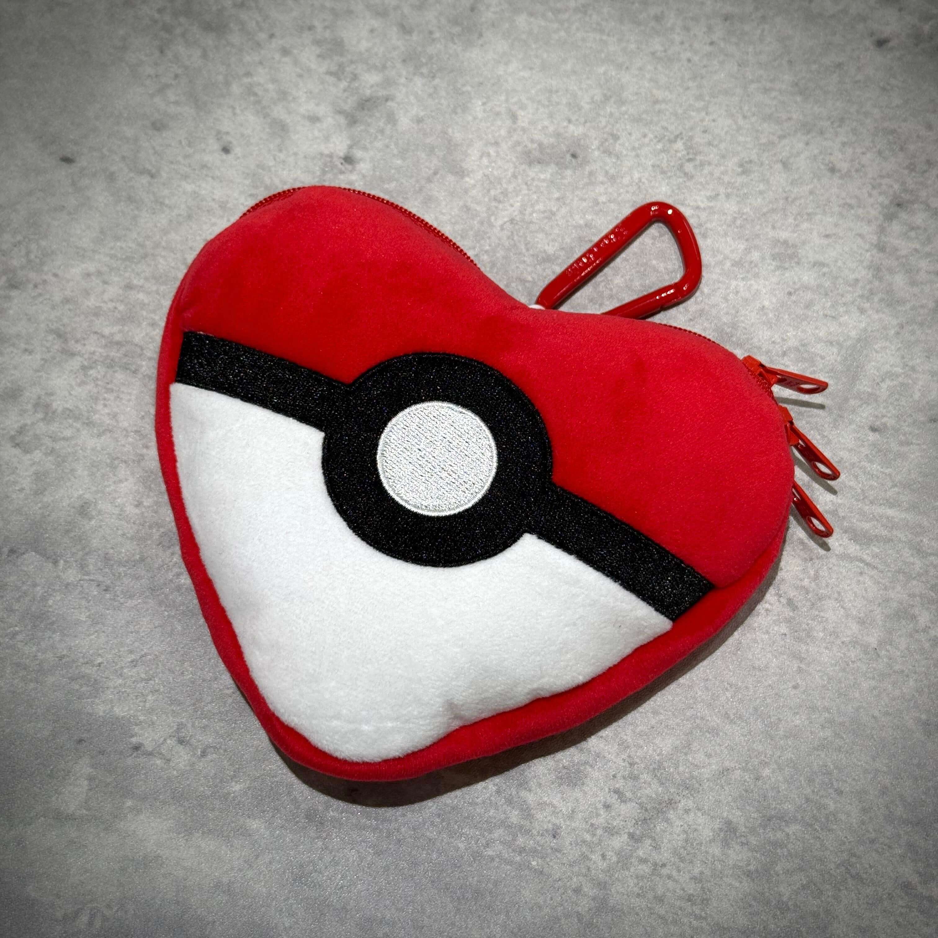 Human Made x Pokemon Heart Stuffed Passcase, red heart pouch with Pokeball design, ideal for storing cards and essentials.