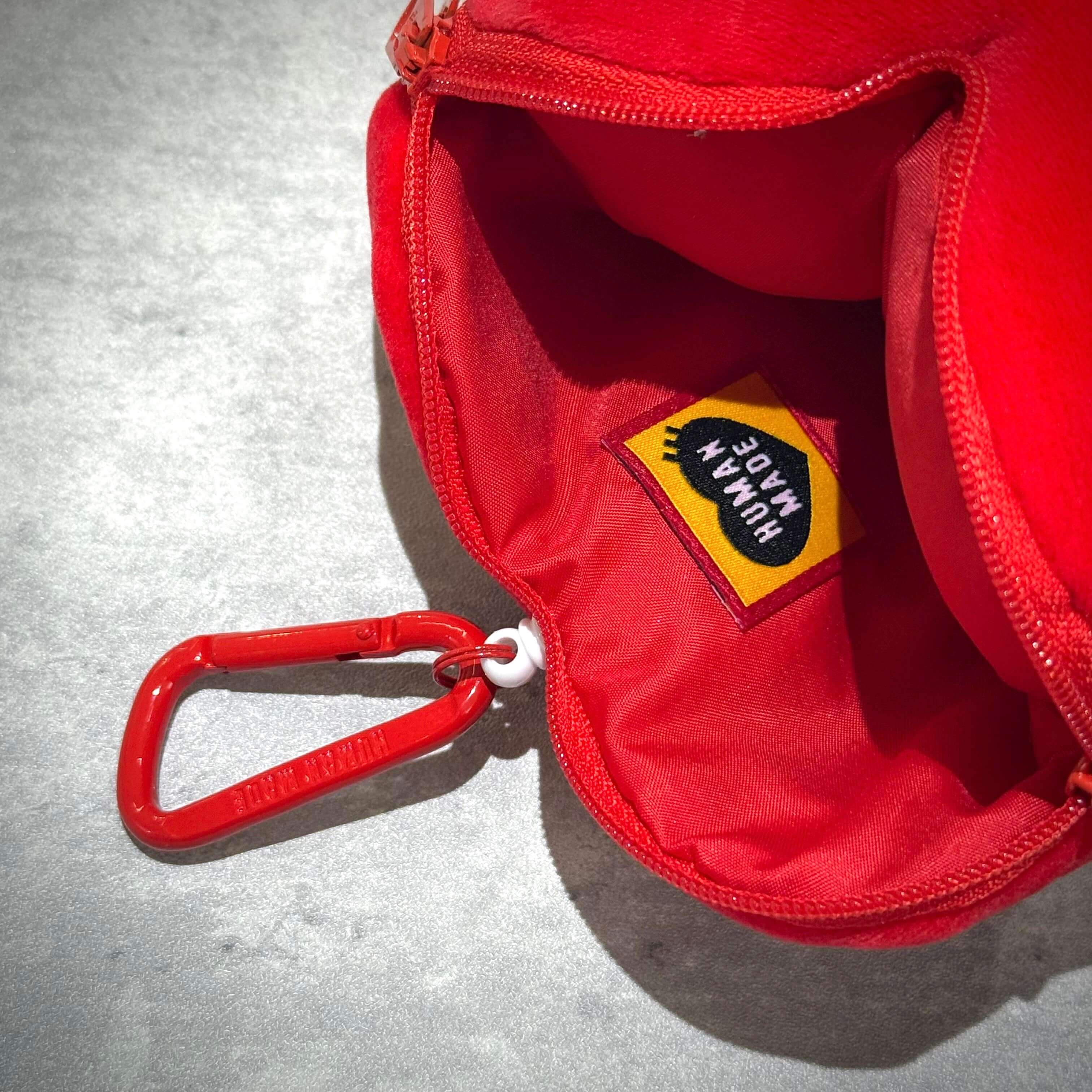Interior view of the Human Made x Pokemon Heart Stuffed Passcase showcasing the brand tag and a red carabiner.