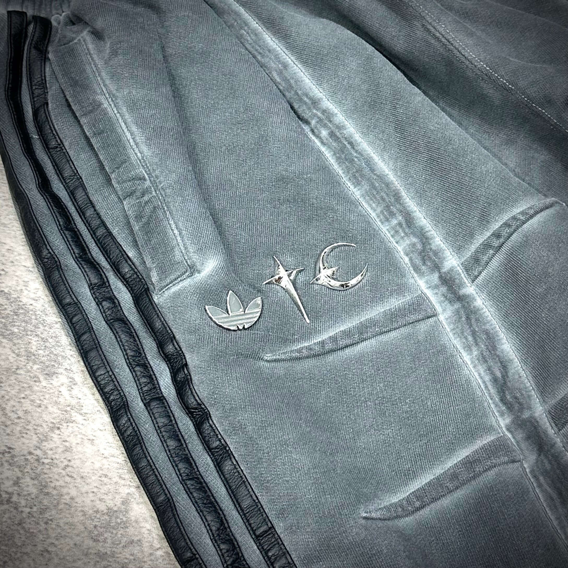 Close-up of Thug Club x adidas Originals Sweat Jort showing logo details on soft fabric.