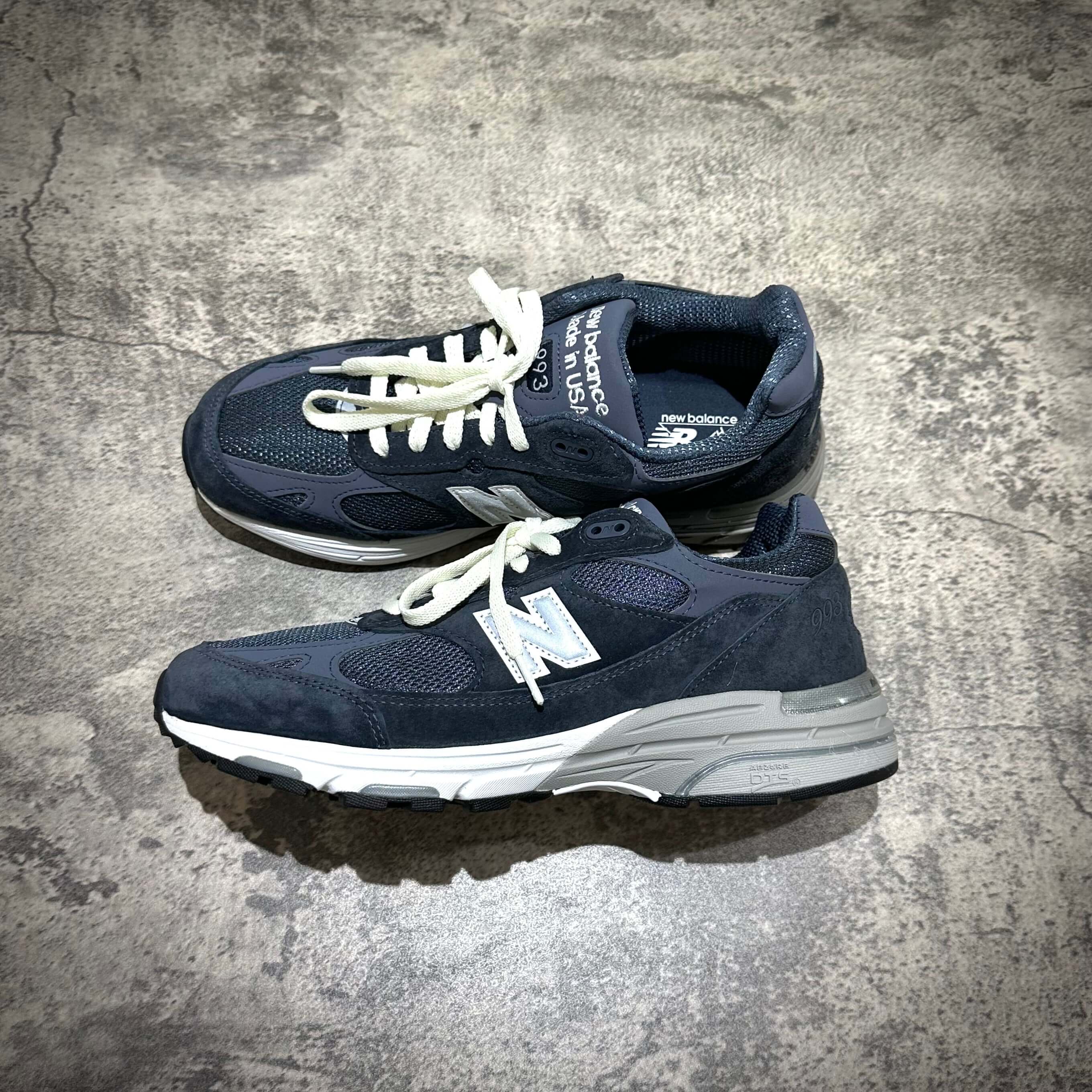 MiUSA Kith x New Balance 993 Asteroid navy sneakers on a concrete surface.