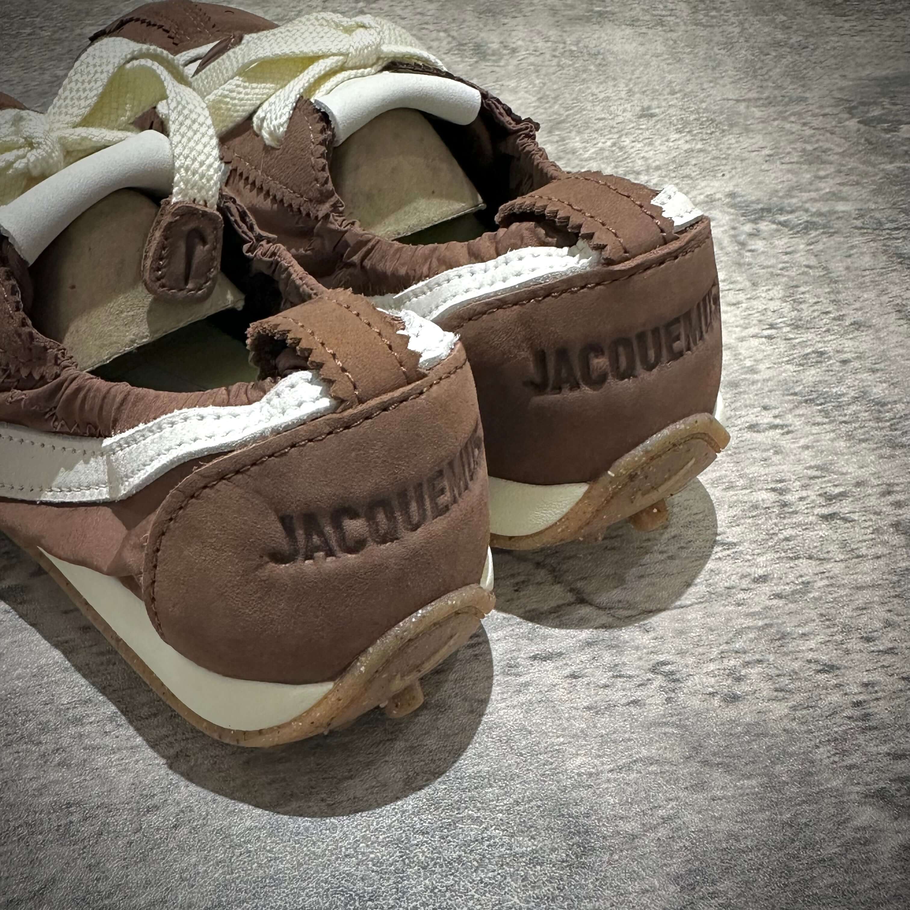 Jacquemus x Nike Moon Shoe SP - Brown, showing the back view with embossed lettering on the heel.