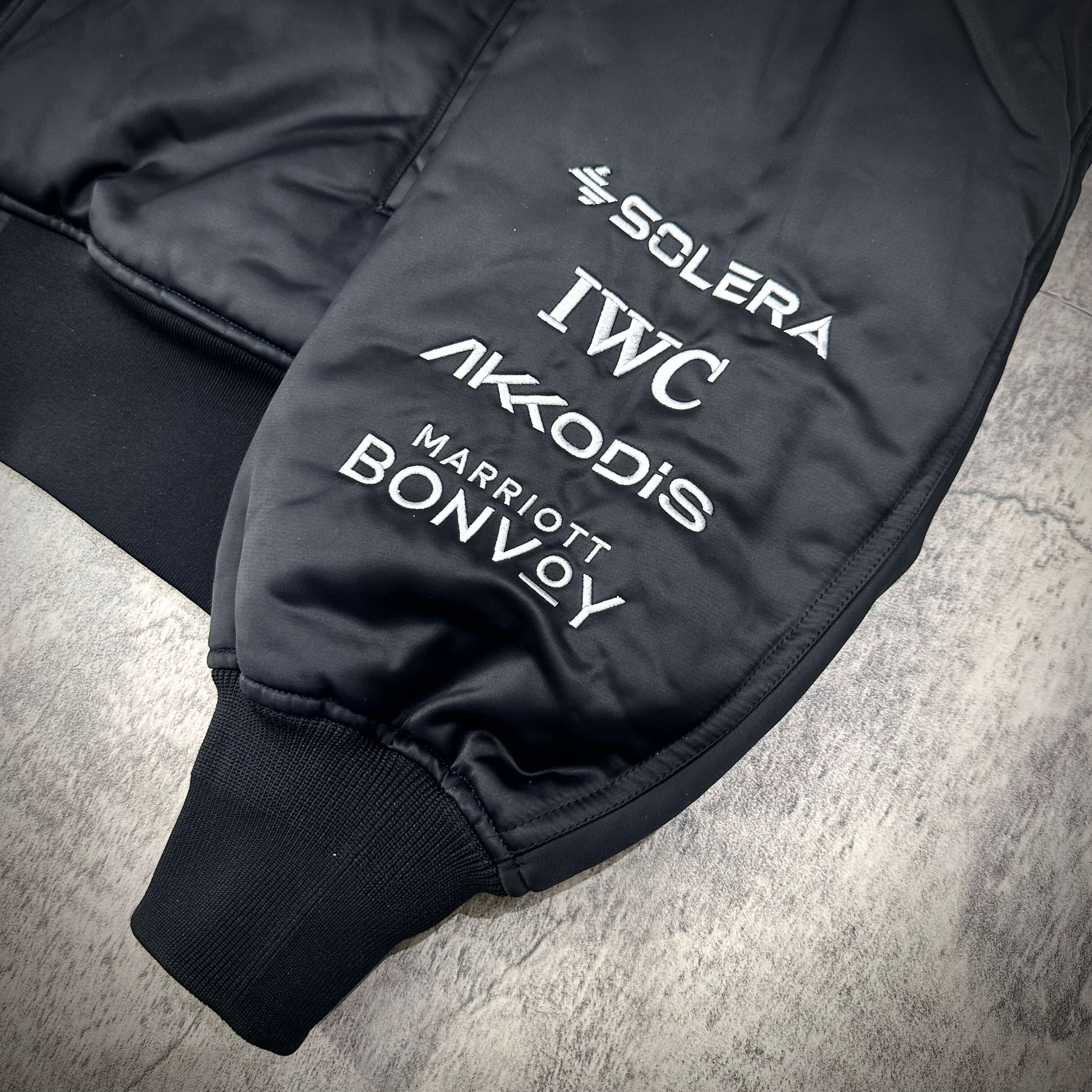 Close-up of Y-3 x Mercedes AMG Petronas F1 Team Jacket featuring sponsorship logos.
