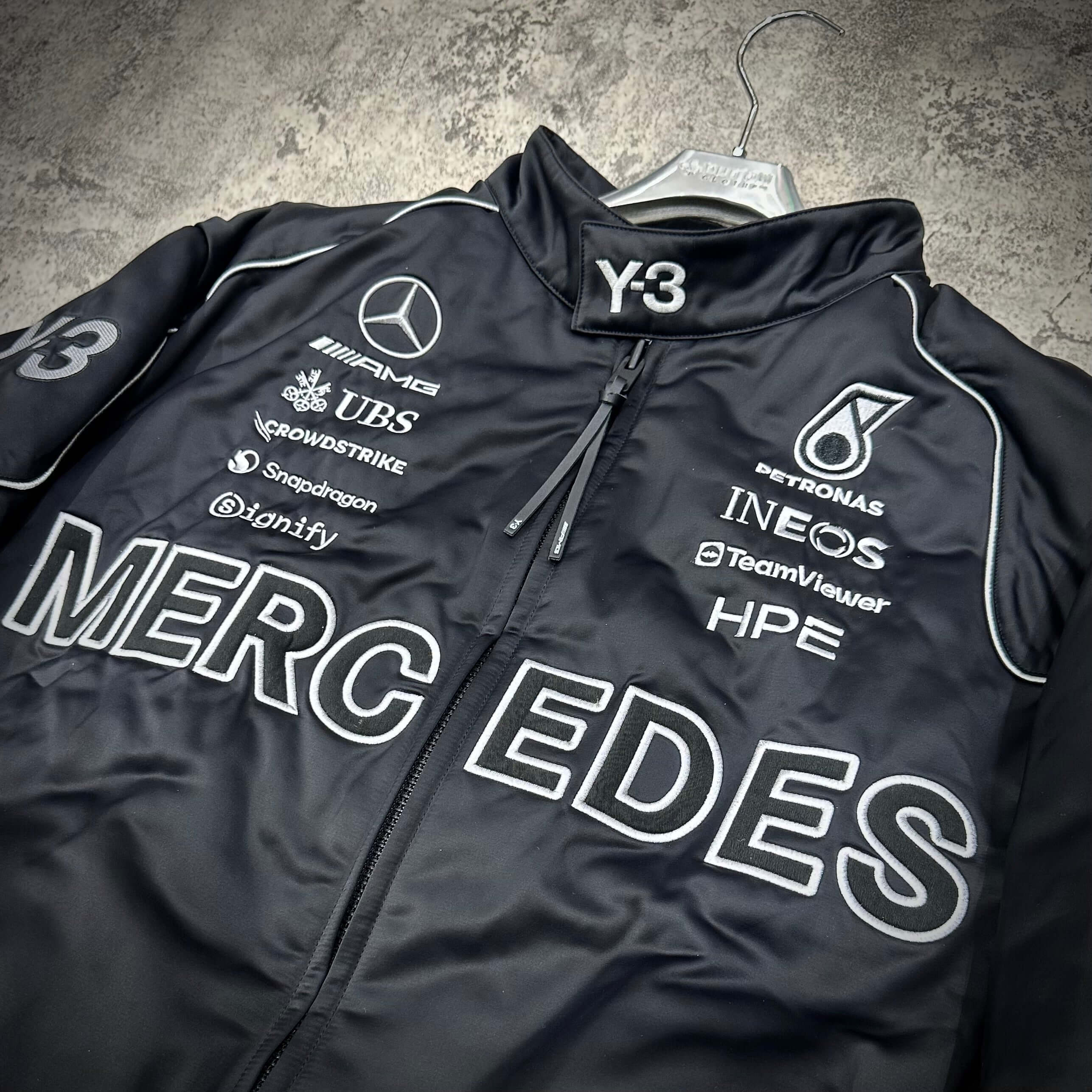 Y-3 x Mercedes AMG Petronas F1 Team Jacket featuring black fabric and logo details.