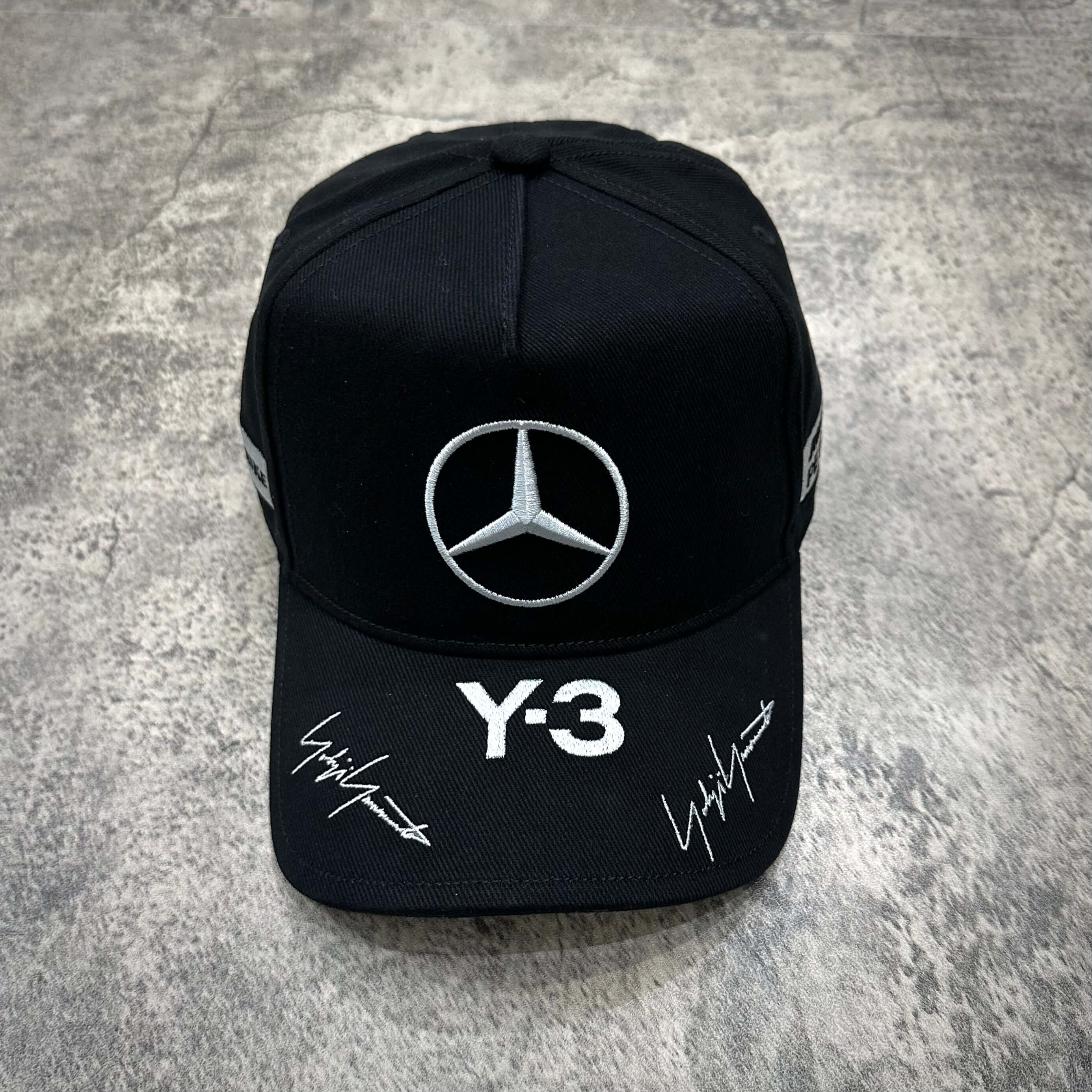 Y-3 x Mercedes AMG Petronas F1 Podium Cap in black and grey with Mercedes logo and signatures.