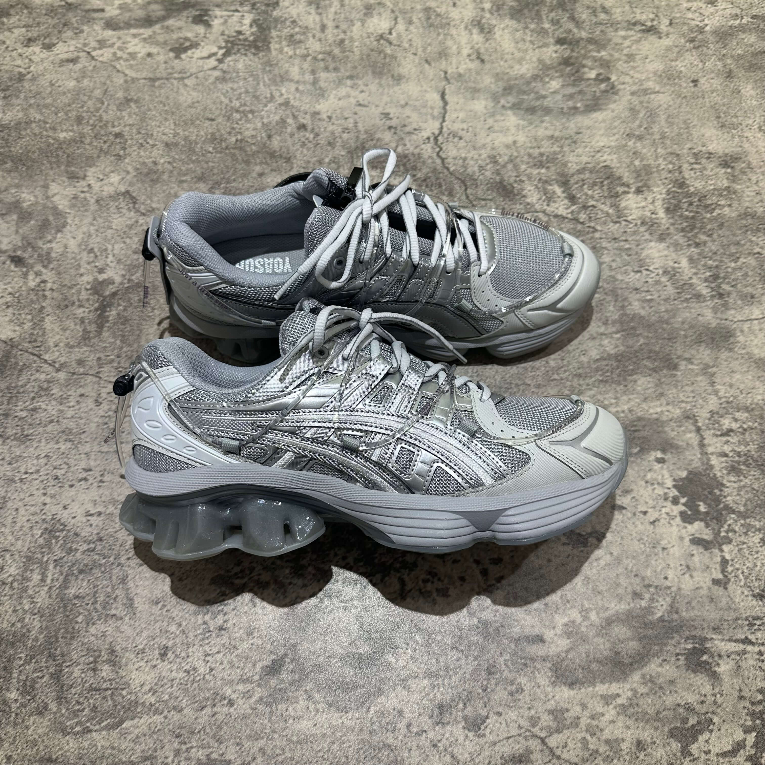 Yoasobi x Asics Gel Kinetic Fluent Y shoes in Piedmont Grey and Pure Silver, showcasing stylish design and premium comfort.