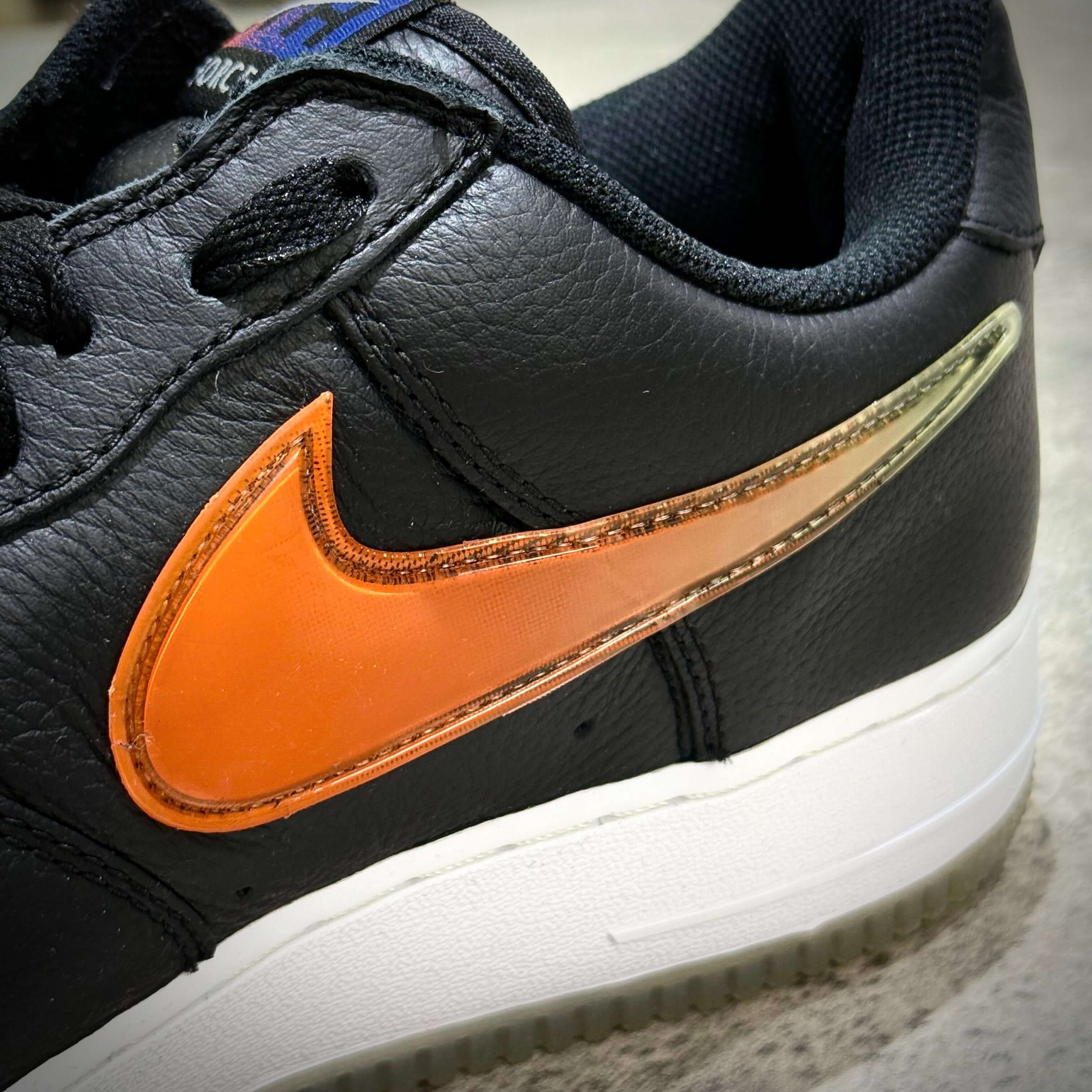 KITH x Nike Air Force 1 Low Knicks close-up of the black sneaker with orange swoosh design